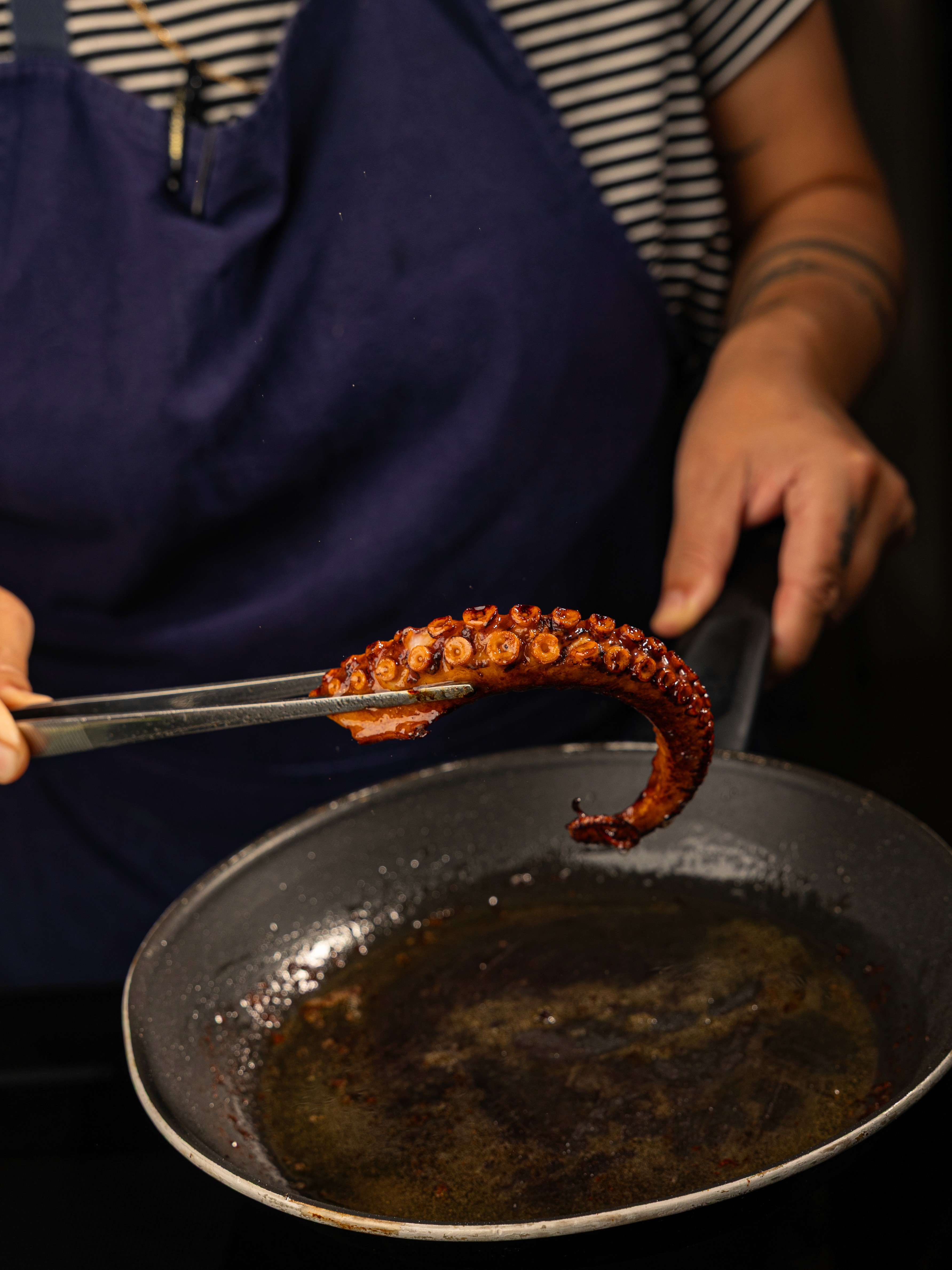 Boca Restaurant Chef preparing an Octopus leg in a pan