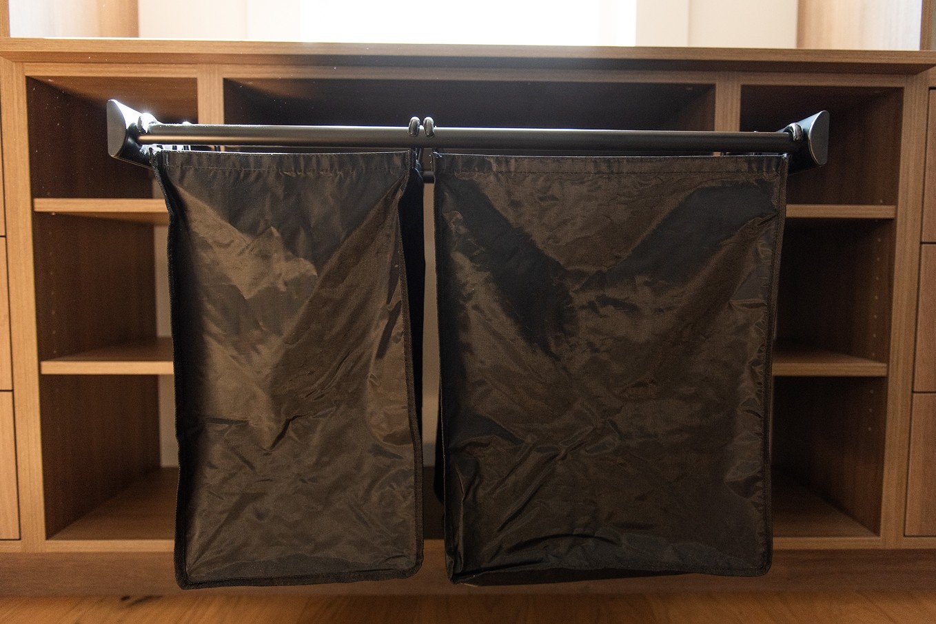 Pull-out laundry bins in custom cabinetry