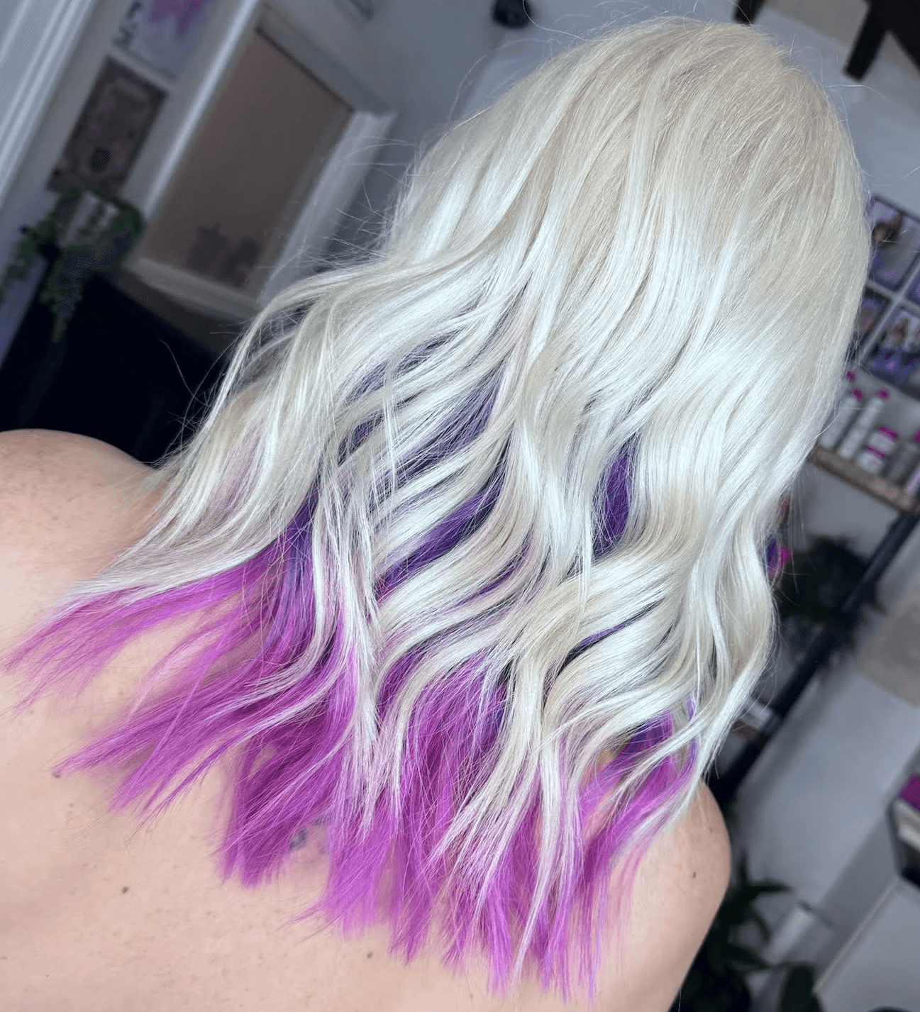 Woman with long wavy blonde hair with purpler highlights at Inspire Studio Salon