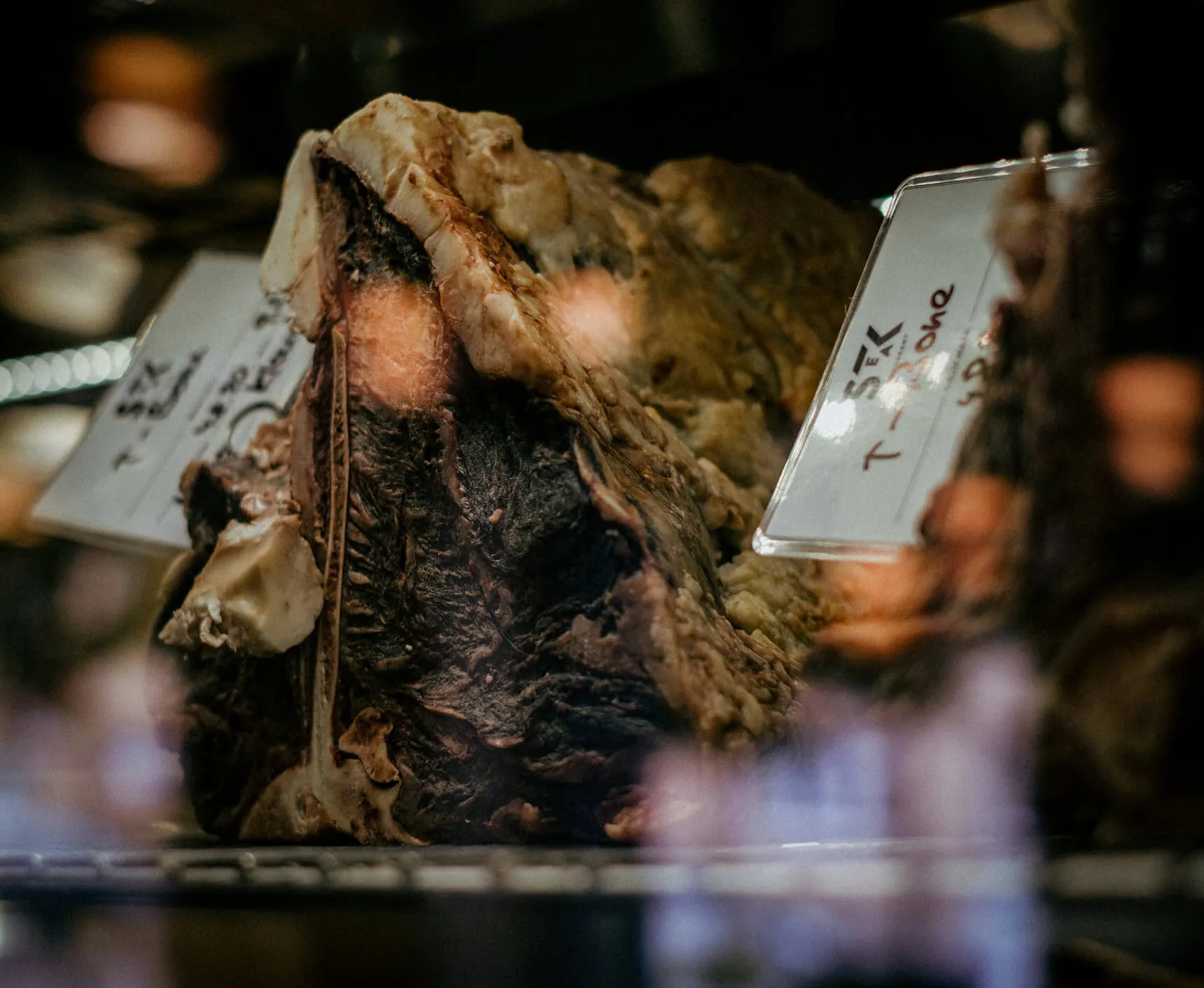 Detail zrání masa Dry Aged, konkrétně T-bone steak, ve speciální chladící vitríně pro maximální křehkost