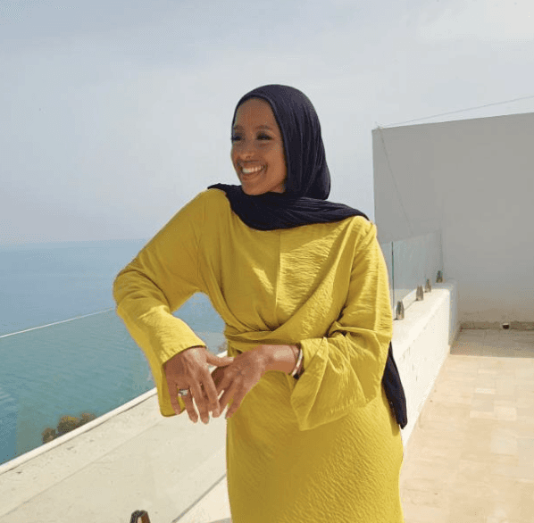 Testimonial photo of young woman in a yellow dress looking at a view