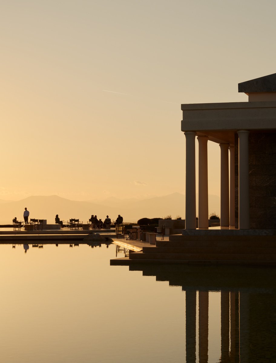 Sunset reflected over Amanzoe’s colonnades and water — serene, architectural, golden.