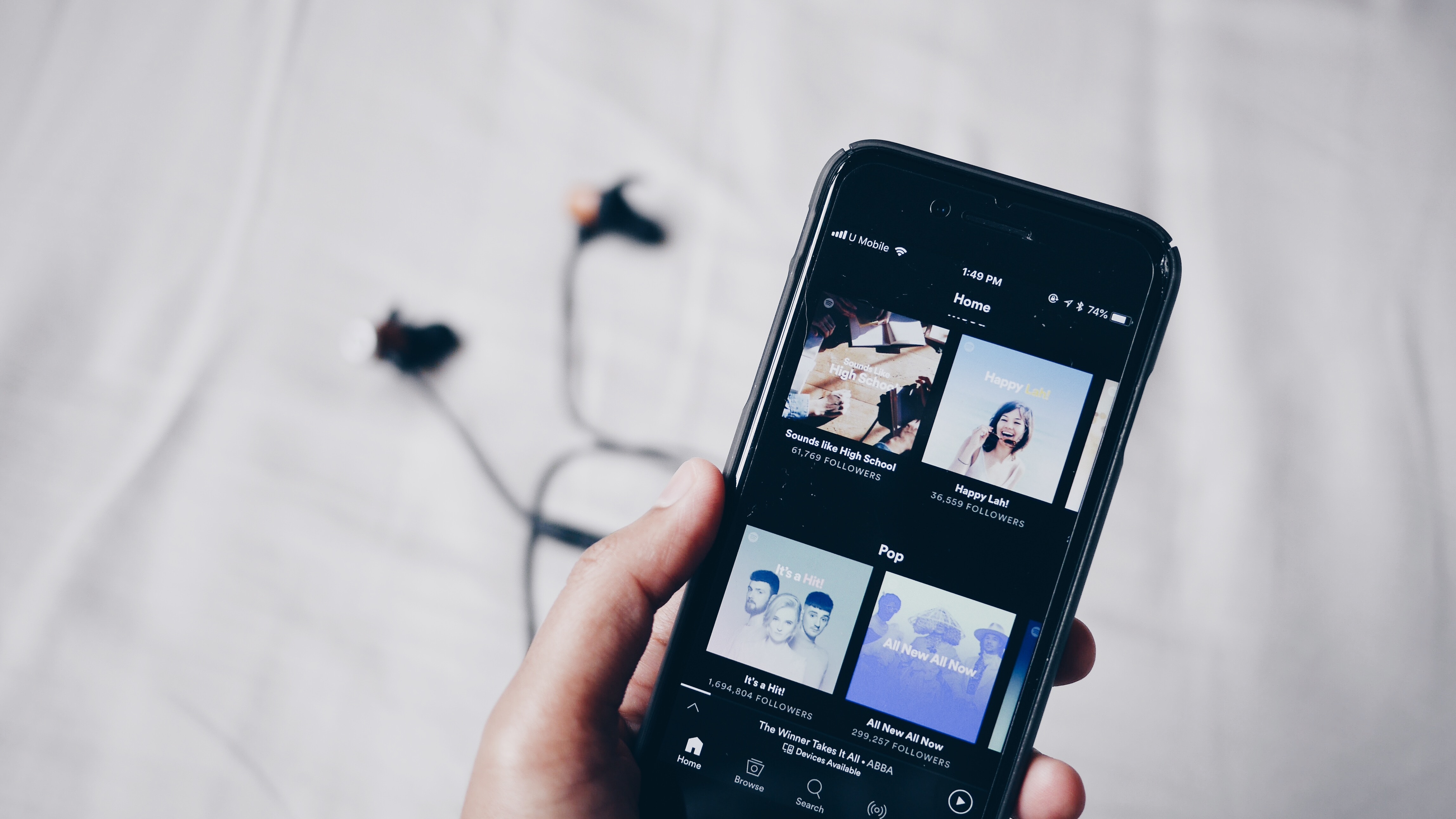 Woman holding mobile with music app - best AI songs