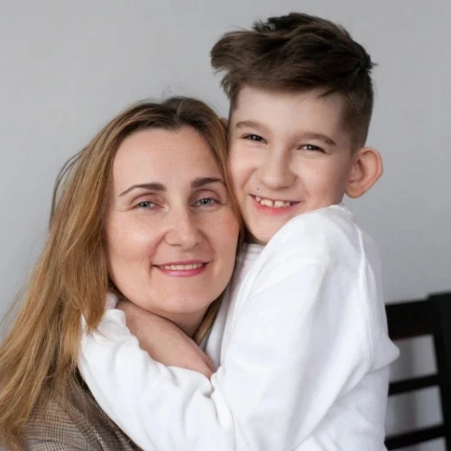 Mother hugging her smiling young son, representing treatment for pediatric penile conditions in Coburg, Melbourne.