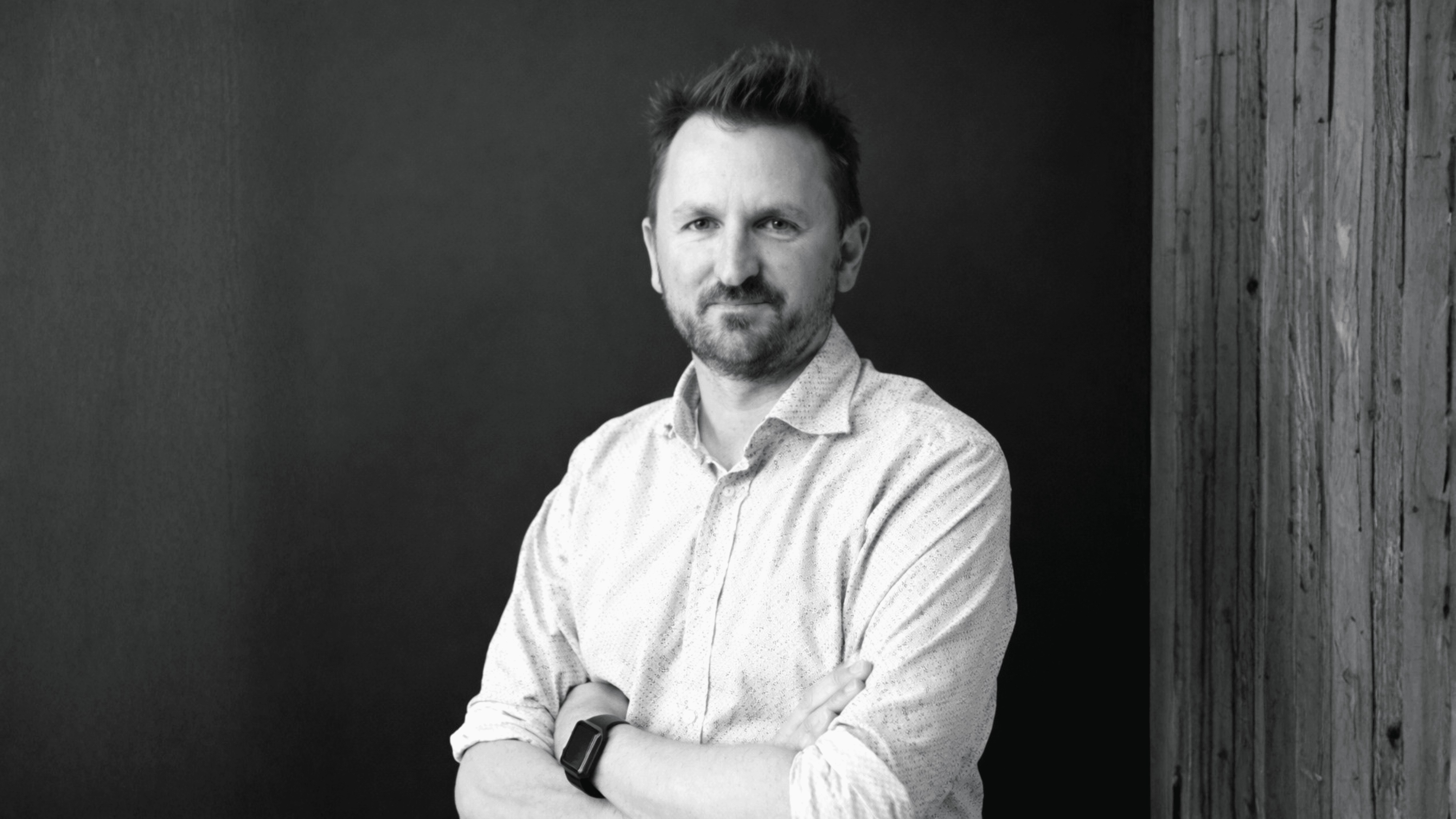 A workspace with tax forms, a calculator, a pen, an envelope, sticky notes, and a cup of coffee on a dark desk.