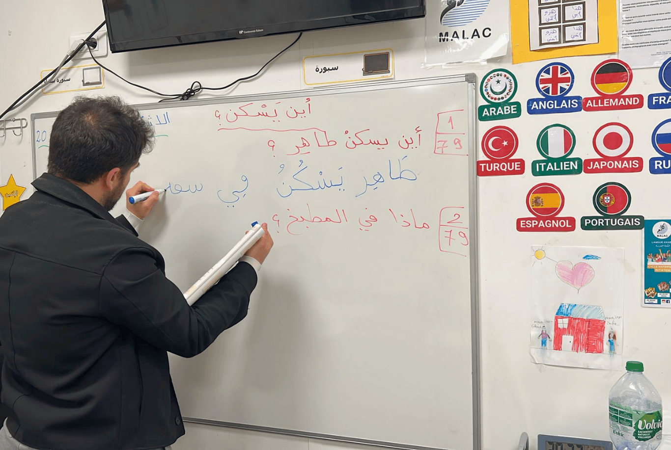 Man writing arabic on the board