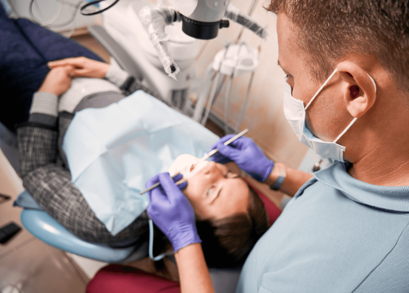 A dentist performing a dental procedure on a patient, ensuring the patient's comfort.