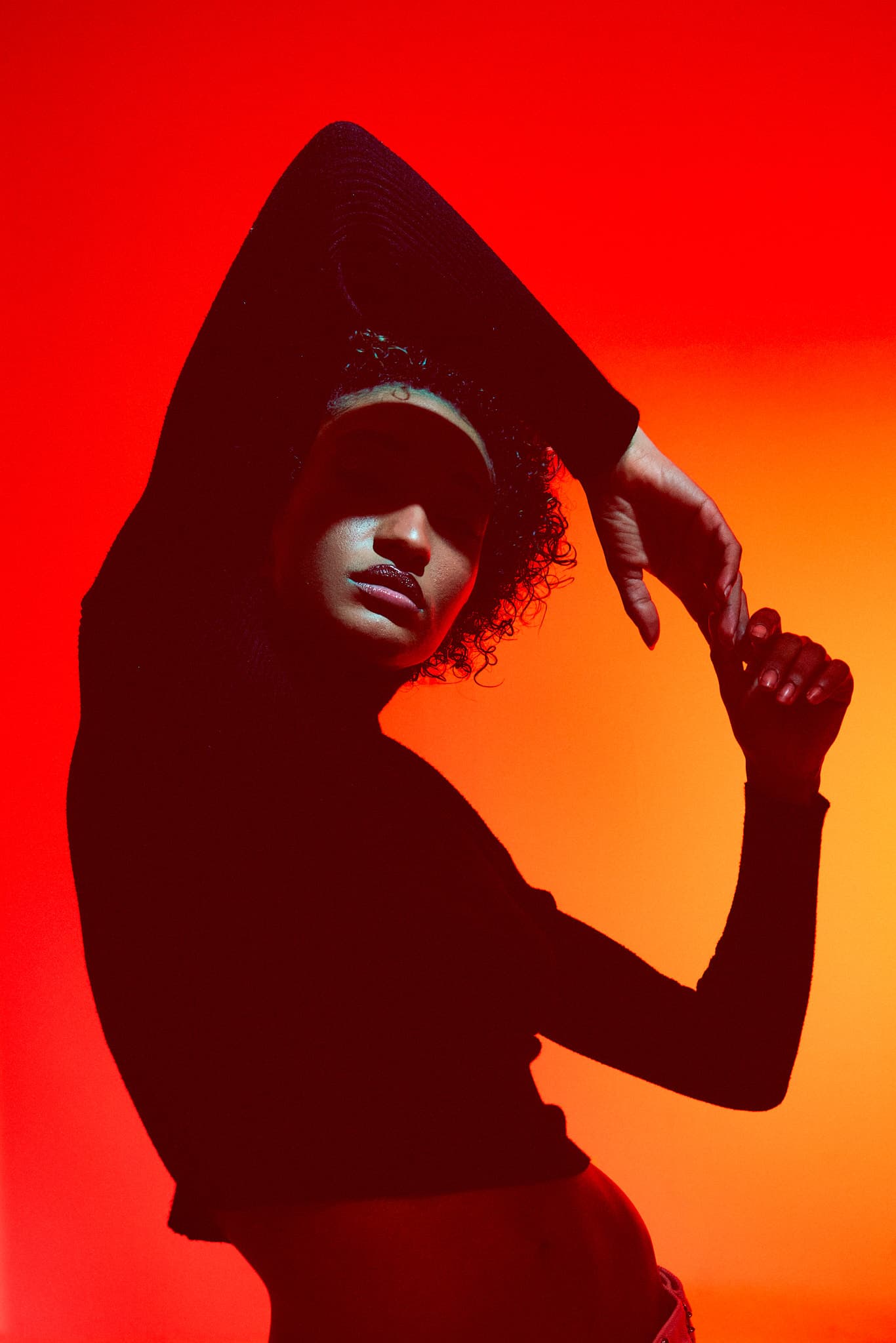 A silhouette of a model posing against a bold red background at Revelator Studio, Shreveport.