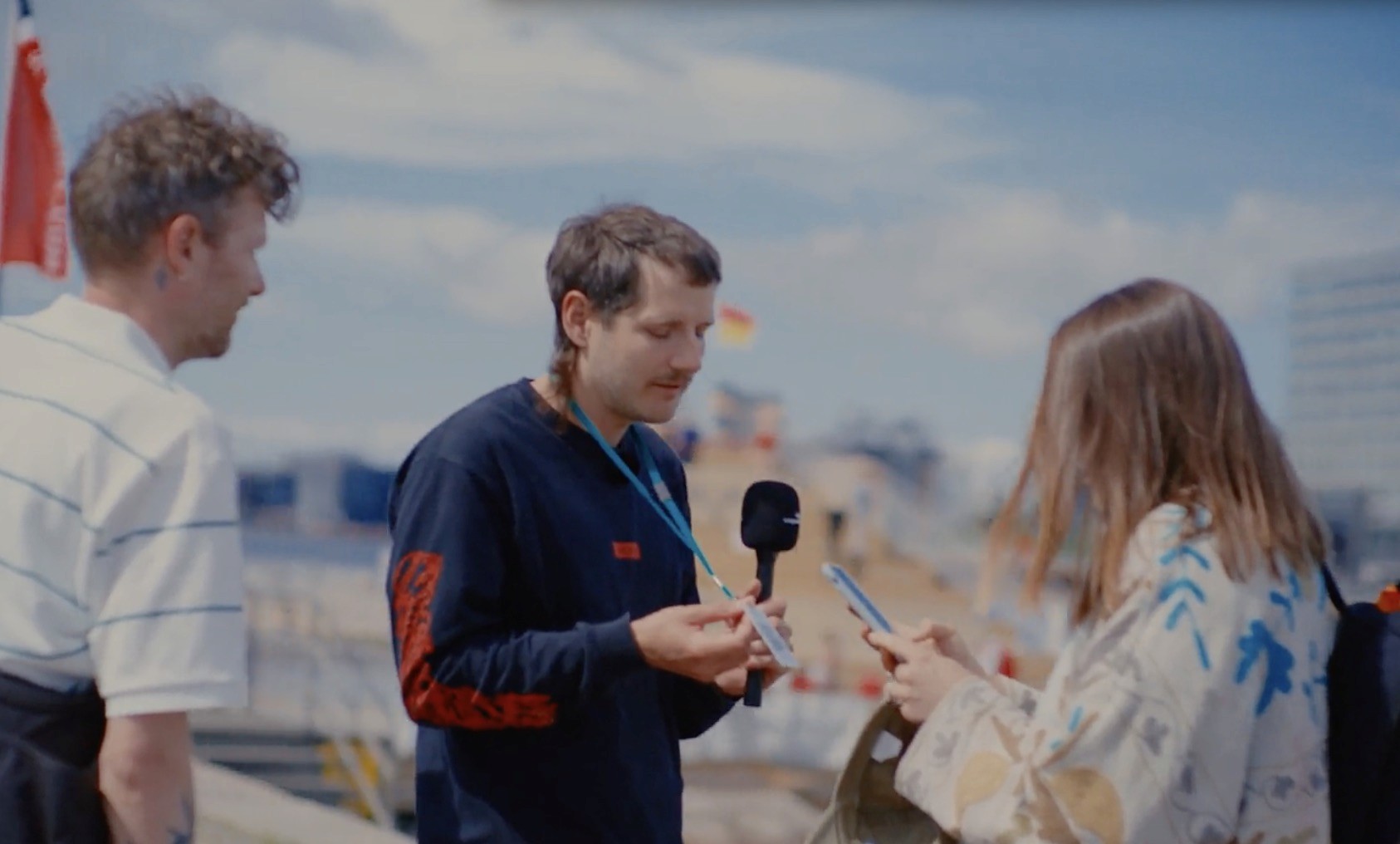 A content creator speaking with two people and collecting consent.