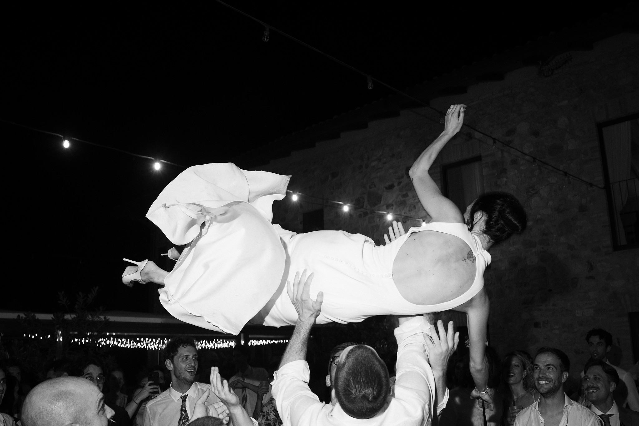 Sposa sollevata in aria dagli ospiti durante il ricevimento a Parco di Montebello, reportage di matrimonio in bianco e nero