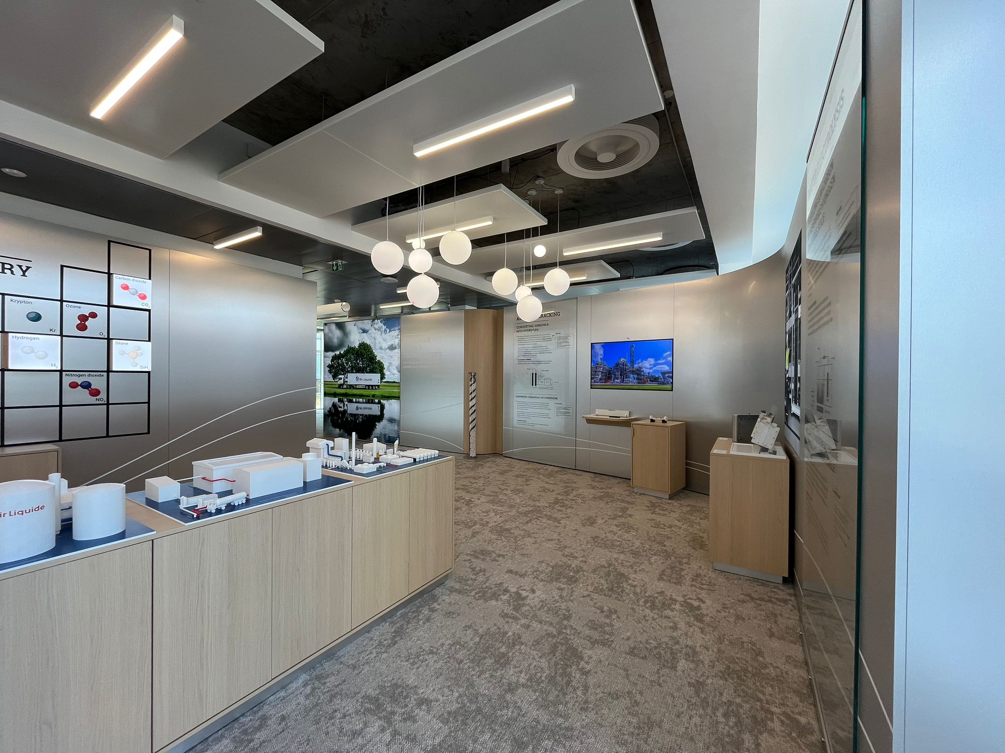 Vue d’ensemble du showroom Air Liquide Paris avec îlot central et espace de présentation