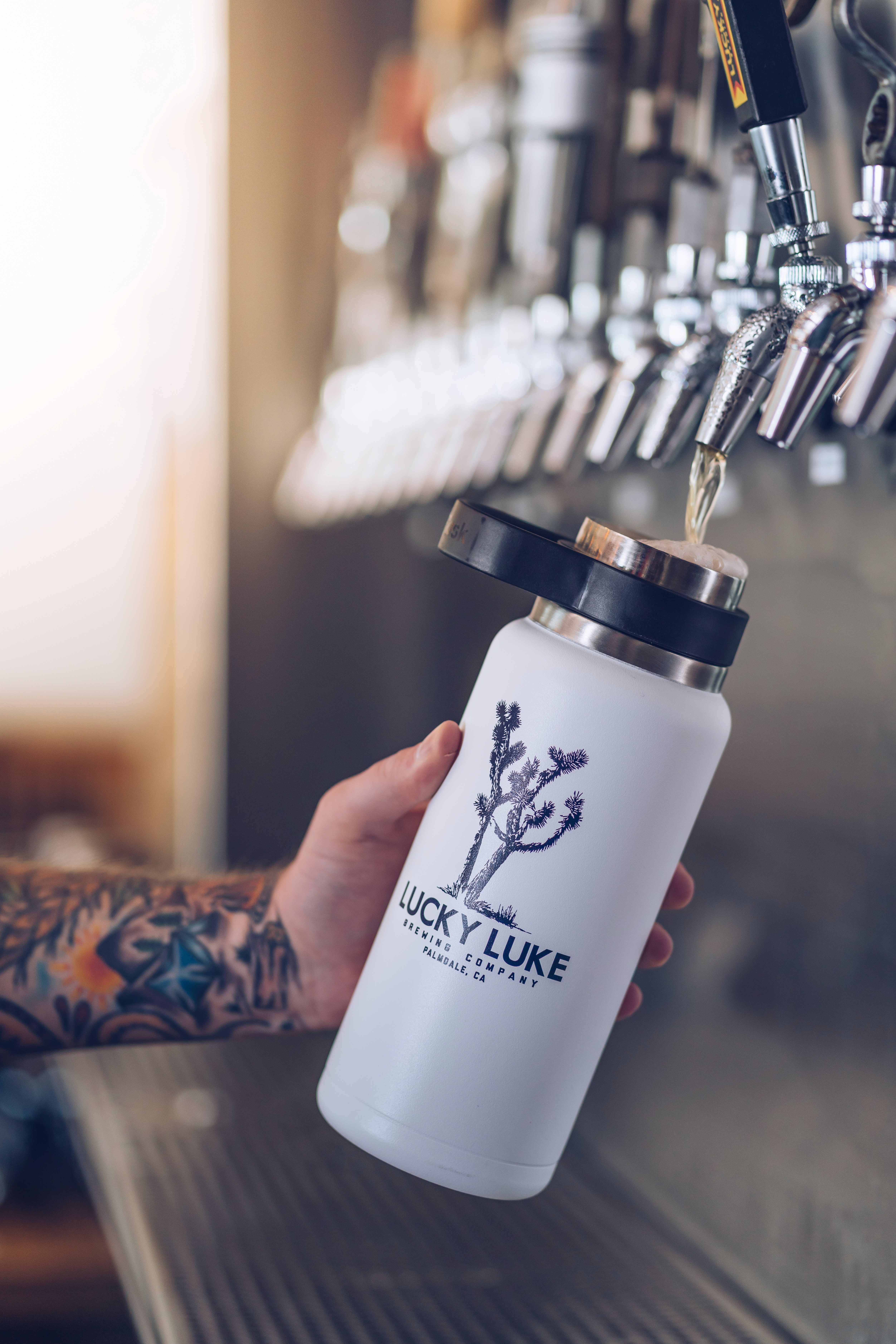 Pouring beer into Lucky Luke branded tumbler