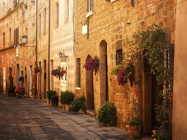 Quiet street in a small Italian town with stone houses and flowers