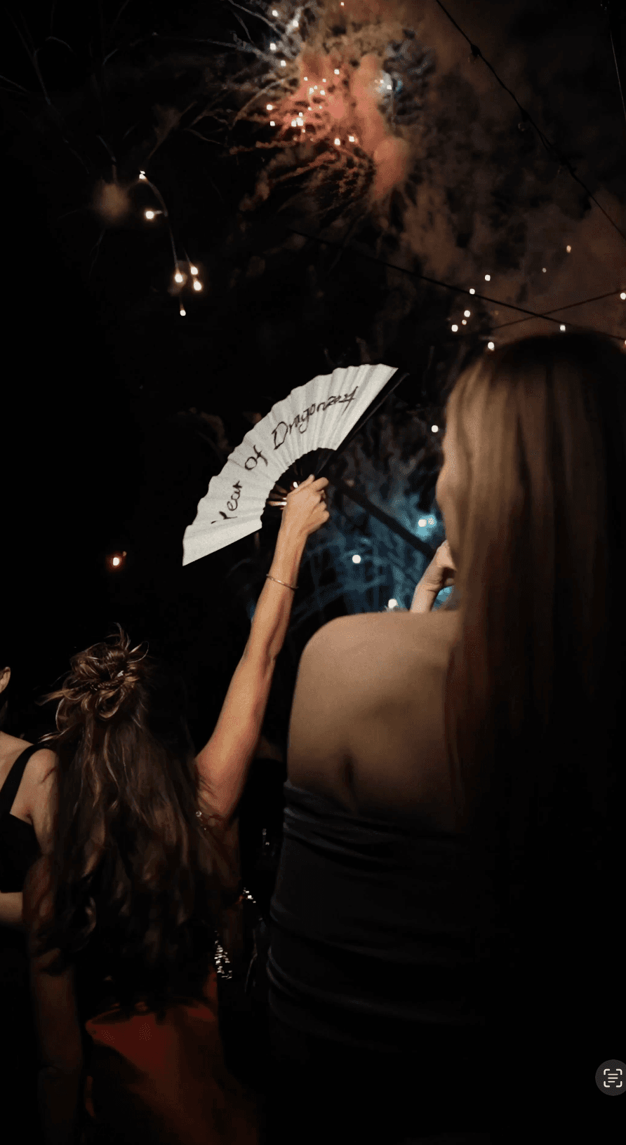 Woman in black outfit posing with arms raised