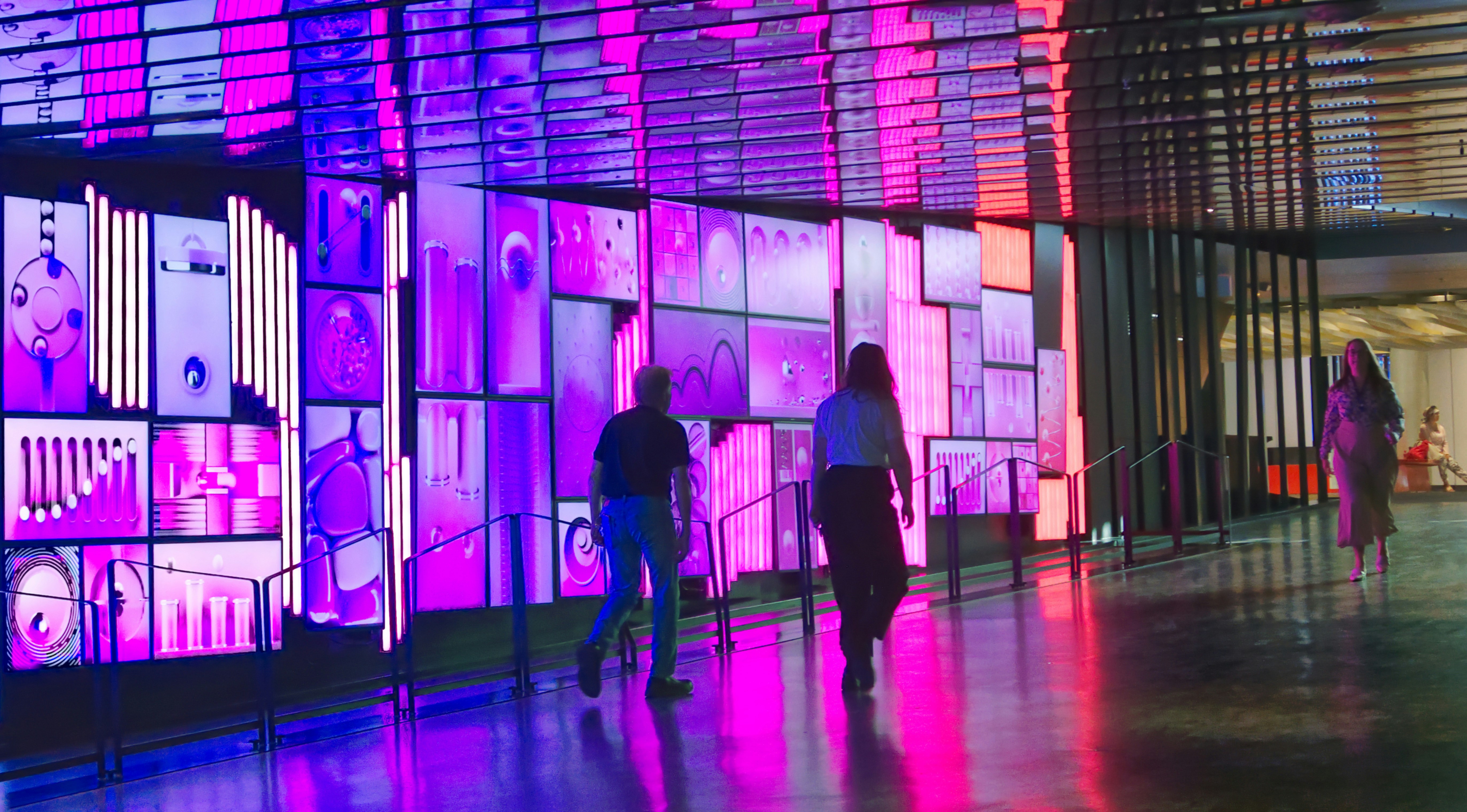 a group of people walking down a walkway next to a building