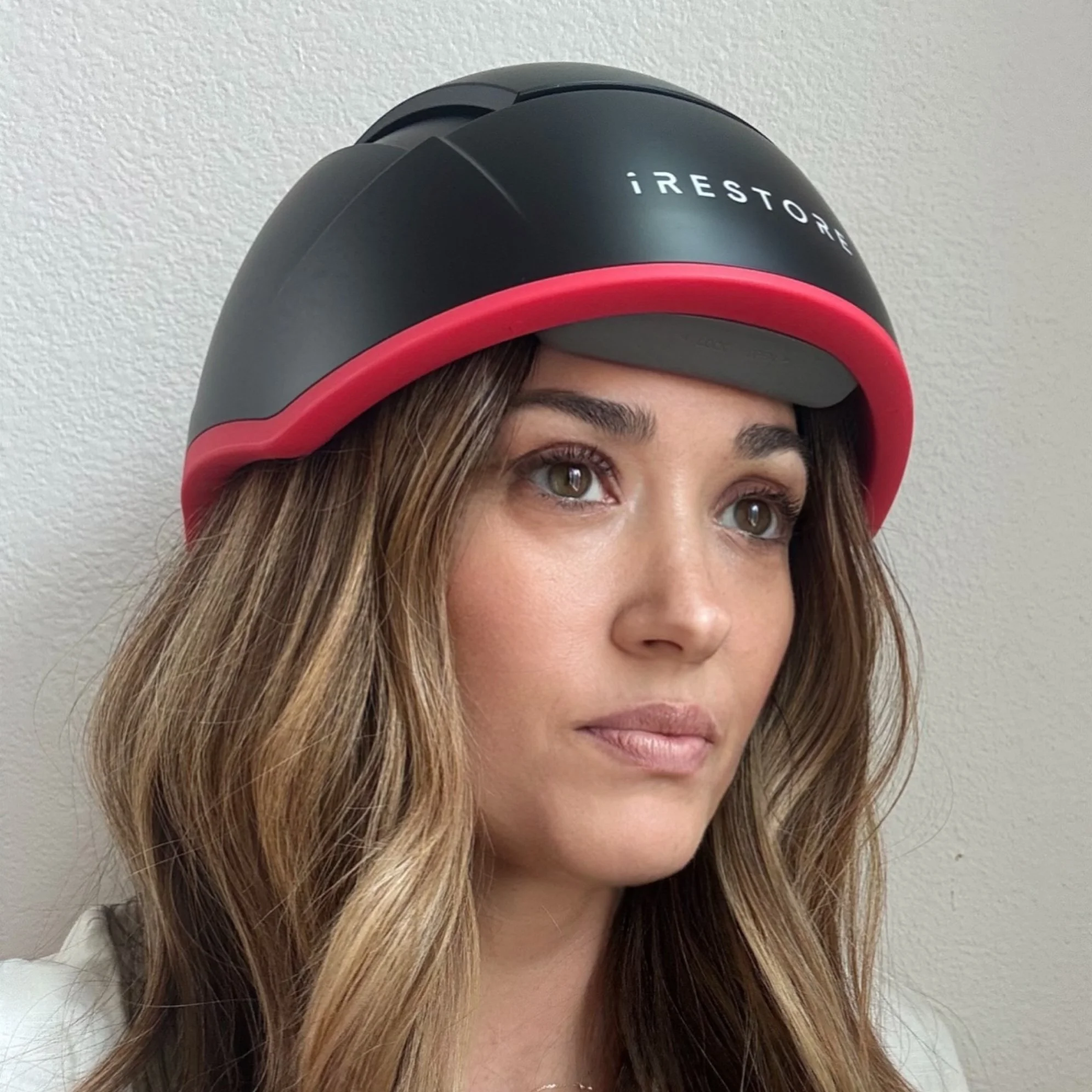 Woman wearing iRestore Red Light Helmet