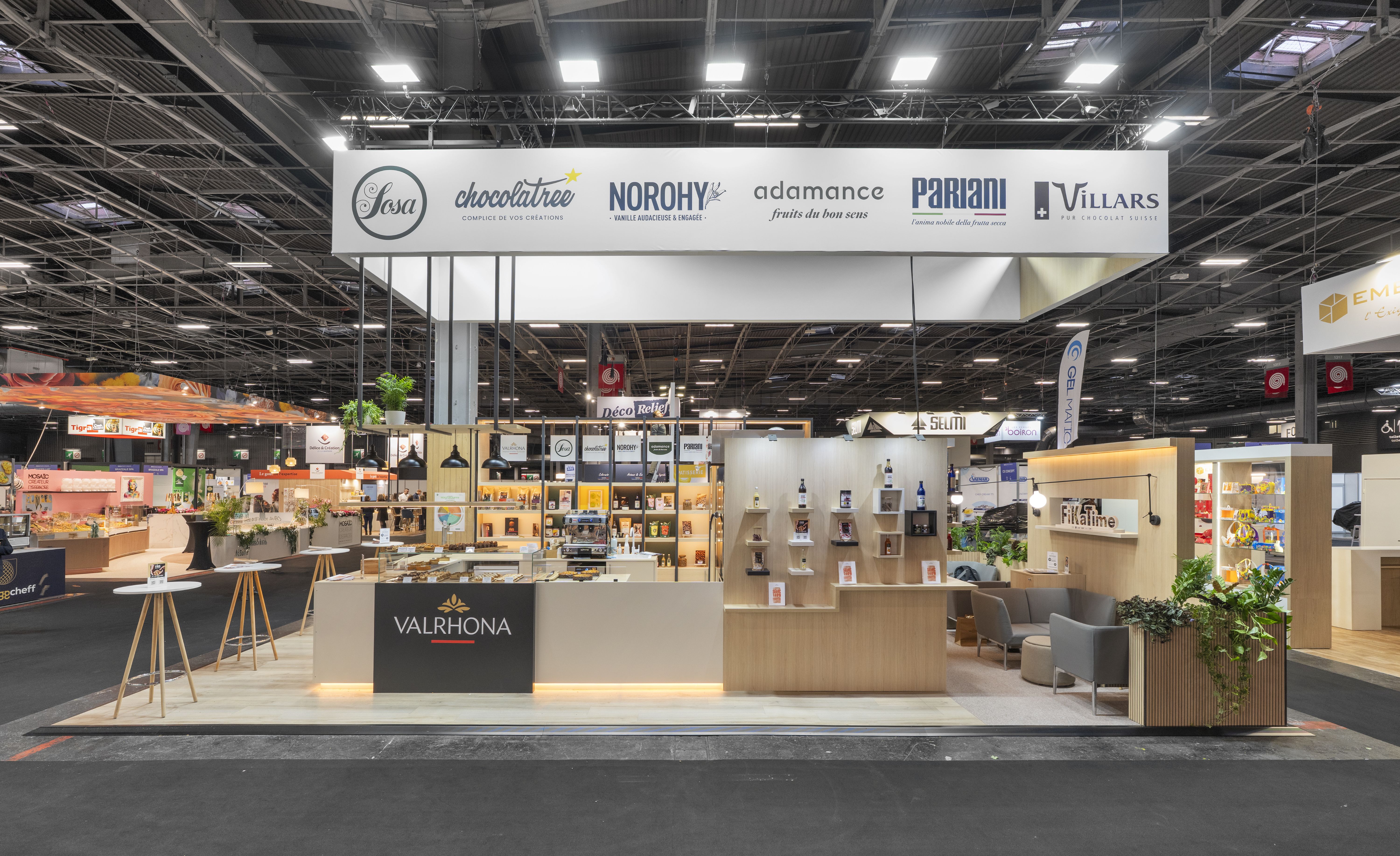 Stand Valrhona Bake and Snack 2026 réalisé par Expace – vue frontale du stand chocolat premium avec structure bois et blanc, zone présentation produits et identité de marque maison chocolatière