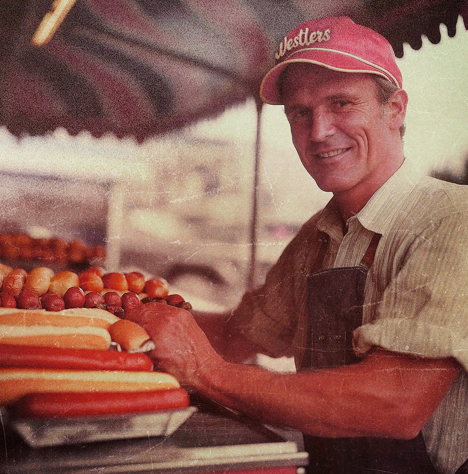 Man serving hotdogs wearing a Westlers cap