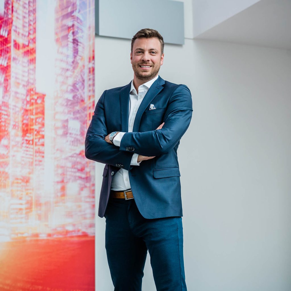 Christopher Essert wearing a suit and smiling in the camera.