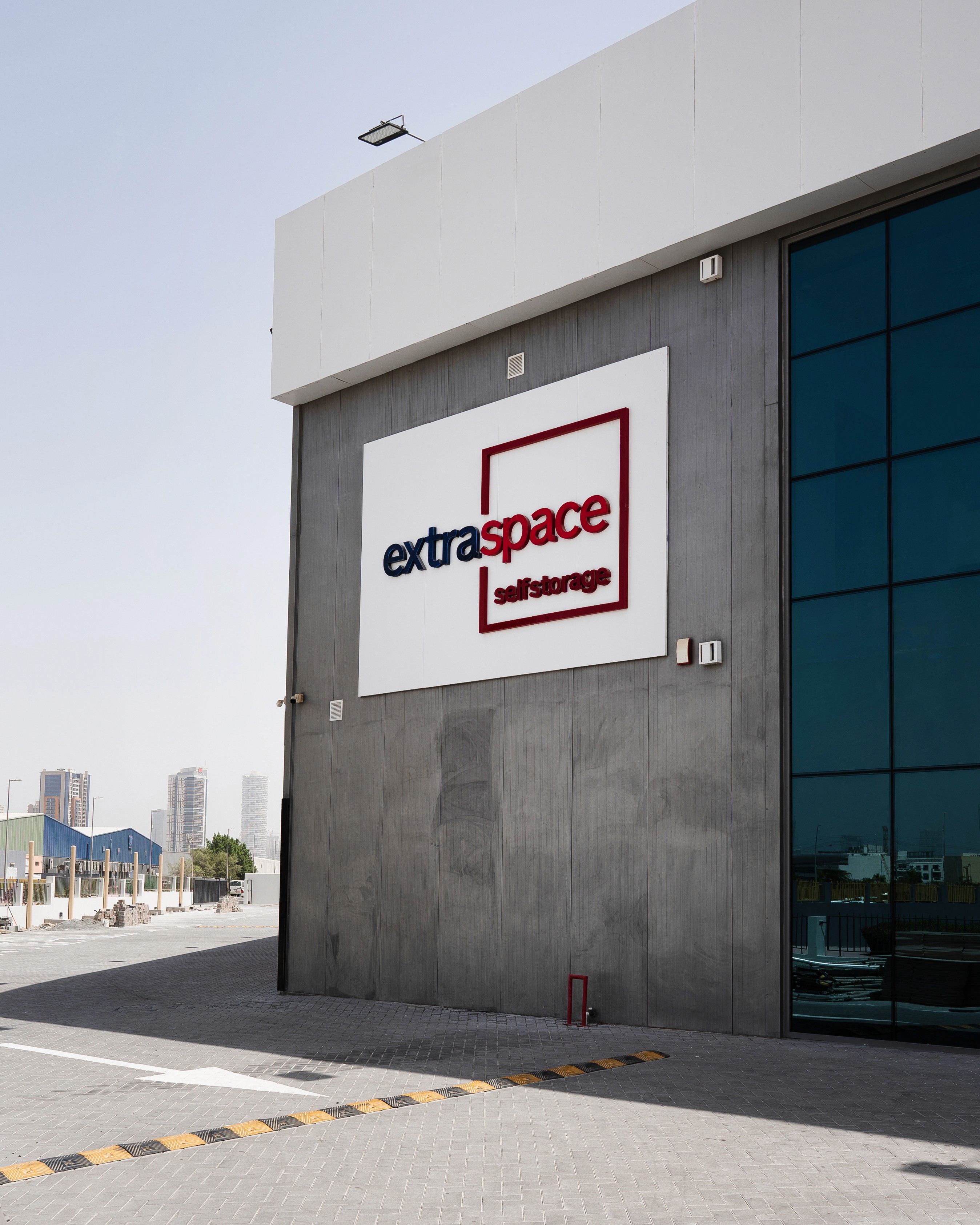 Extra Space car shipping service transporting a dark grey Ferrari in an enclosed white trailer.