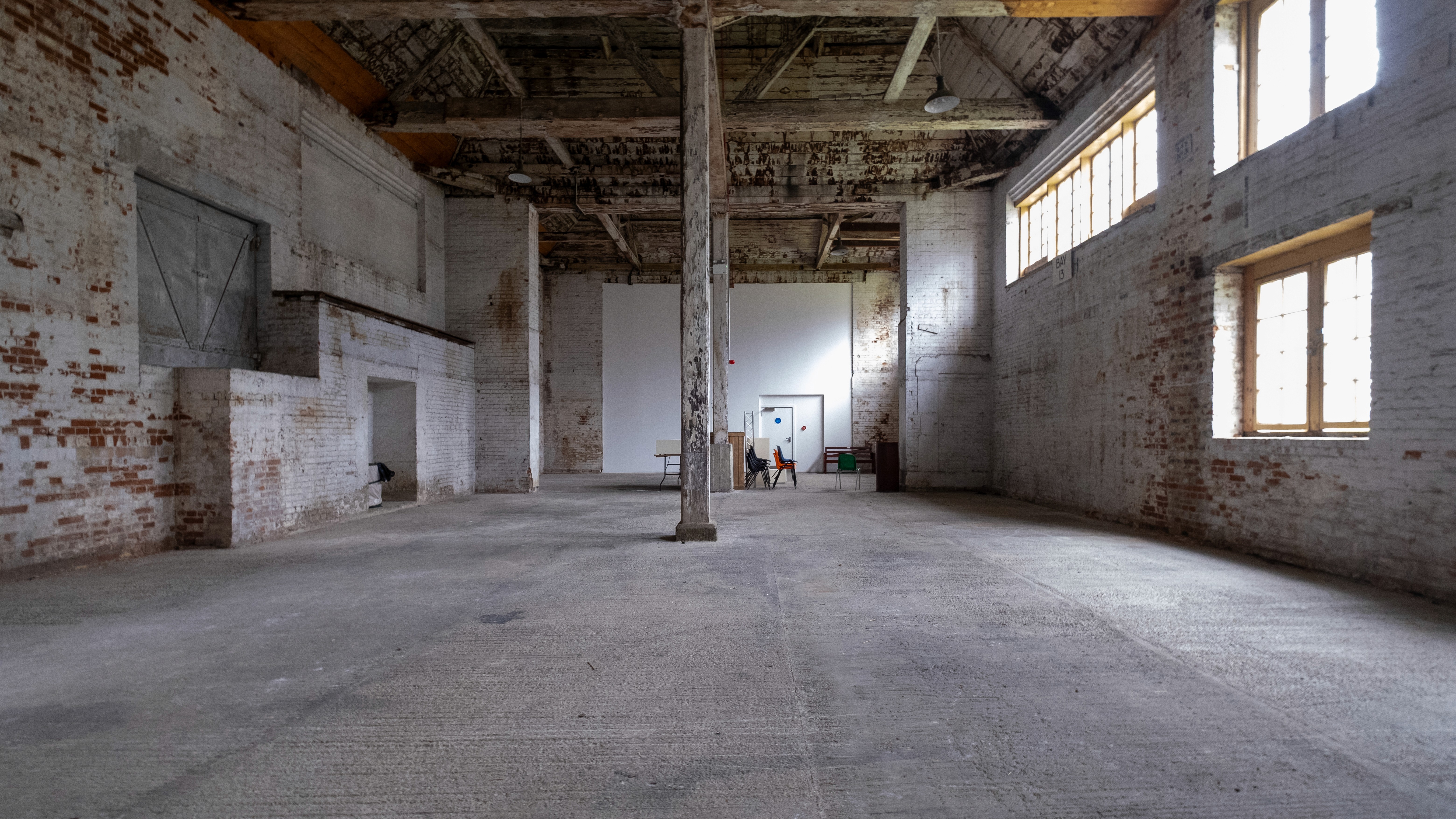 Two classic volkswagen beetles, one green, one cream.