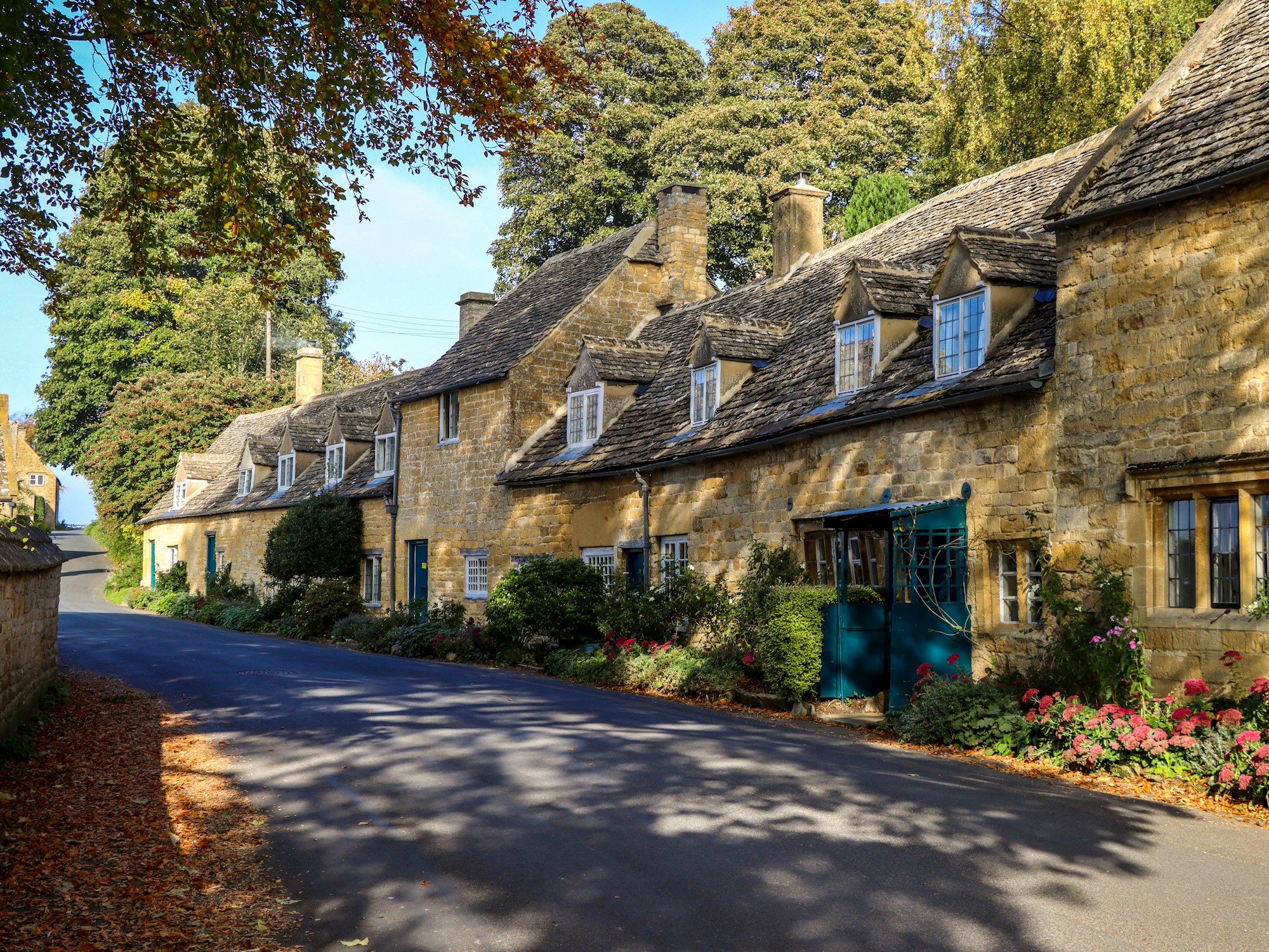 A quiet village road lined with stone cottages on a sunny day