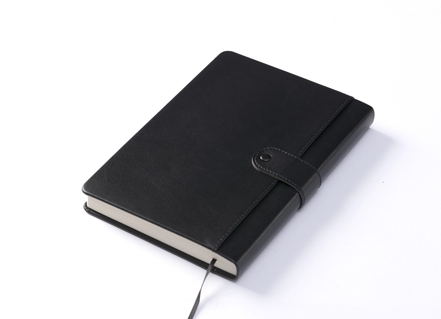 Angled view of closed black notebook with ribbon bookmark.
