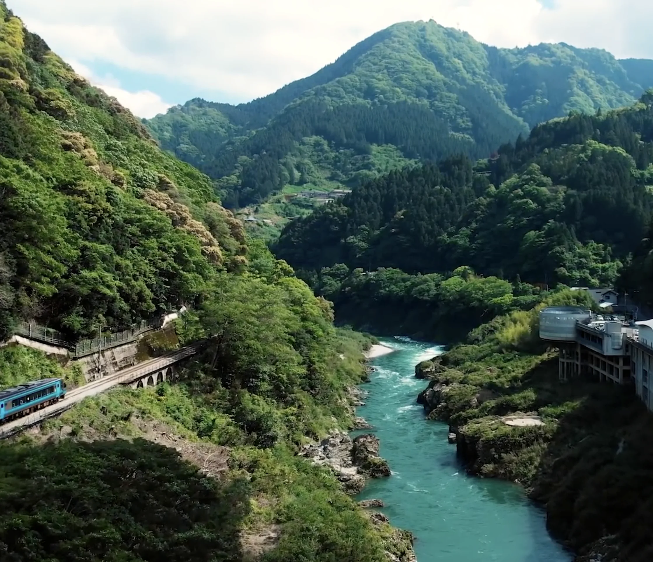 A forested river valley in Japan, seen from above