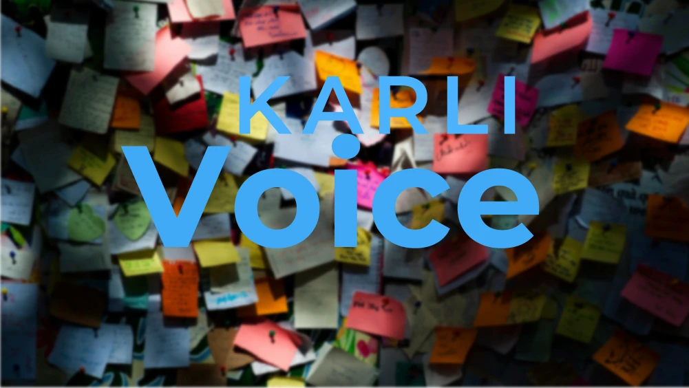 Eine Wand, die voll mit bunten Notizzetteln hängt und mittig im Vordergrund steht KARLI Voice.
