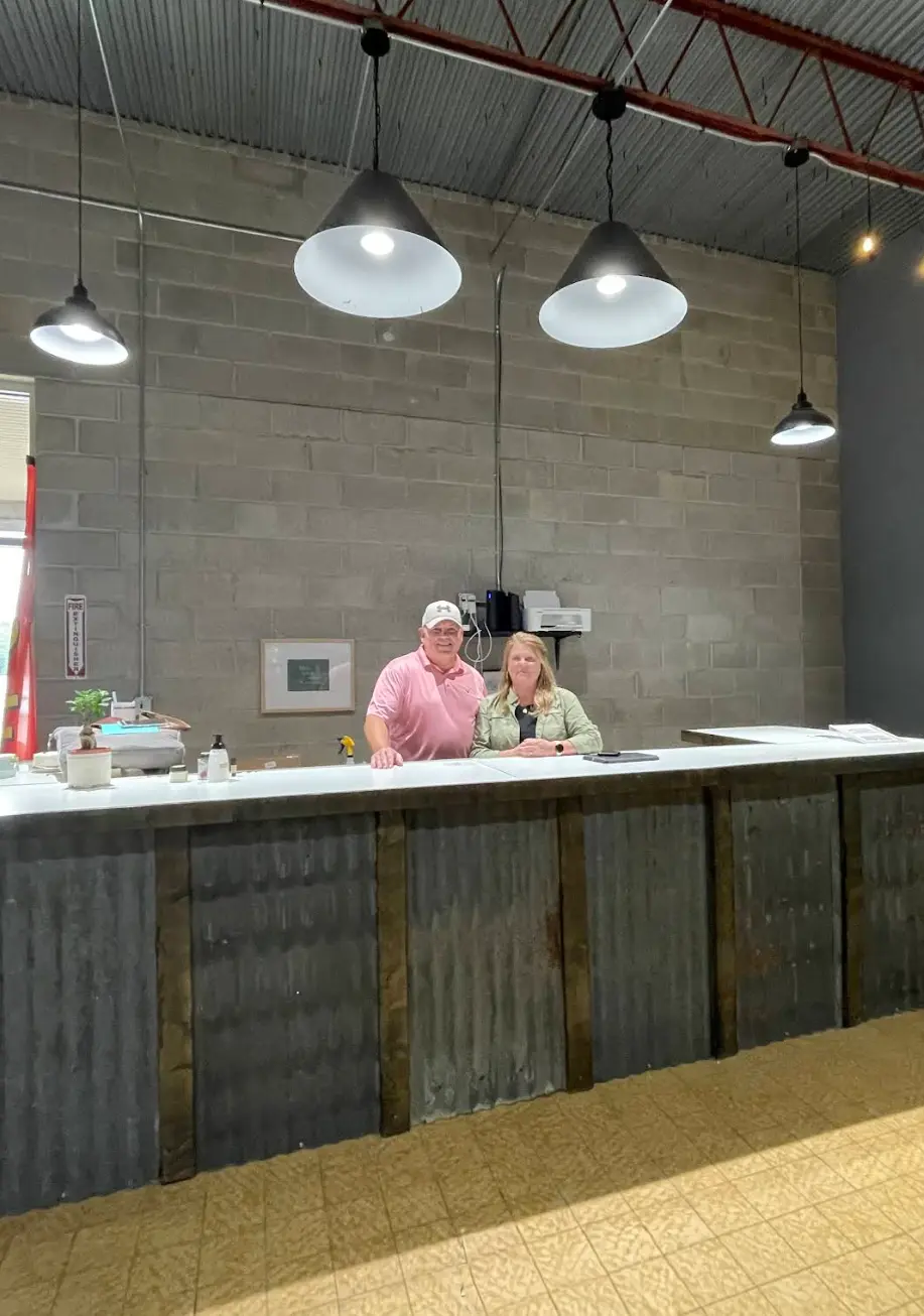 Two staff members standing behind a rustic front counter inside a home decor store.