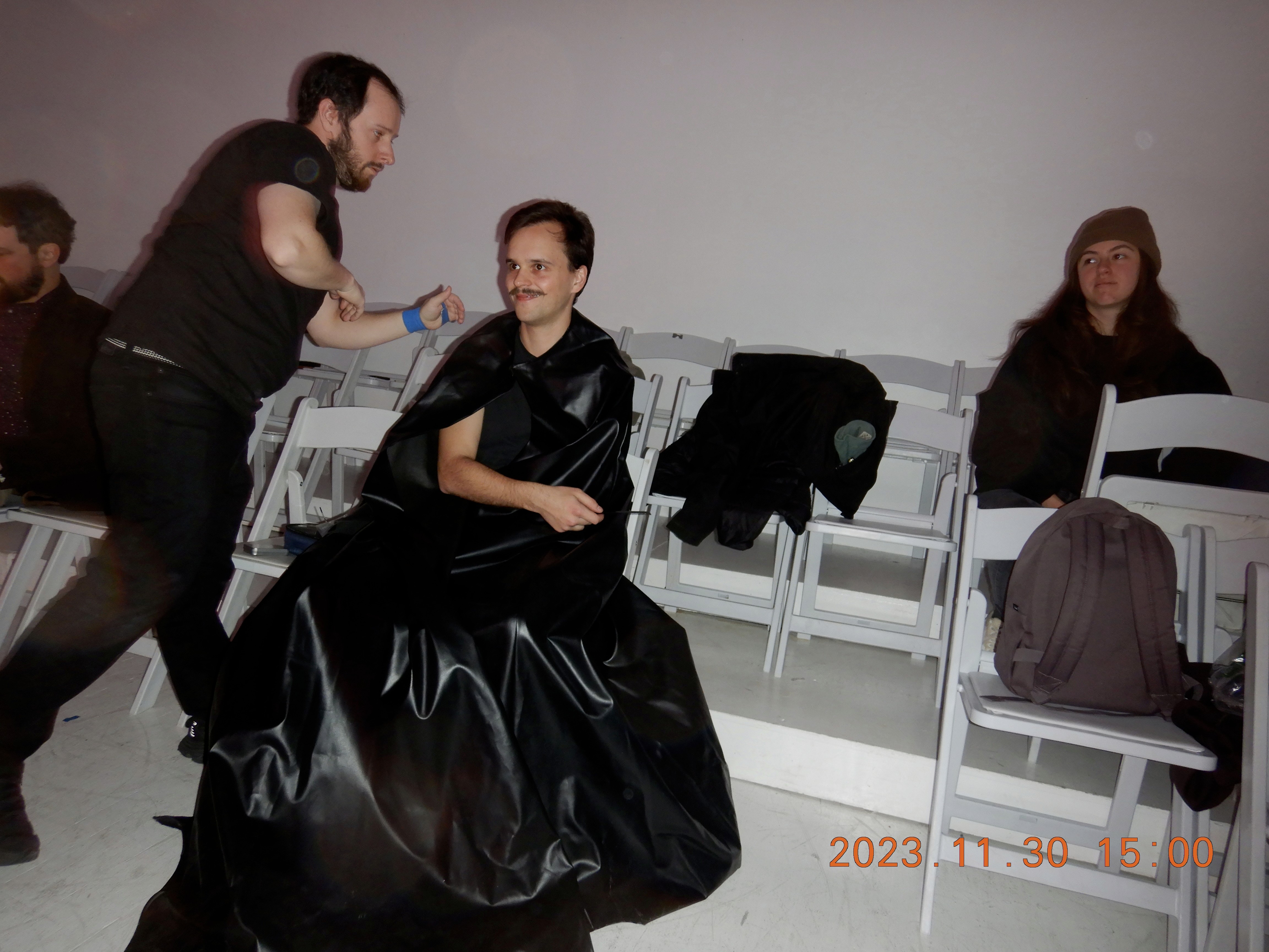 Crew helping an actor into costume