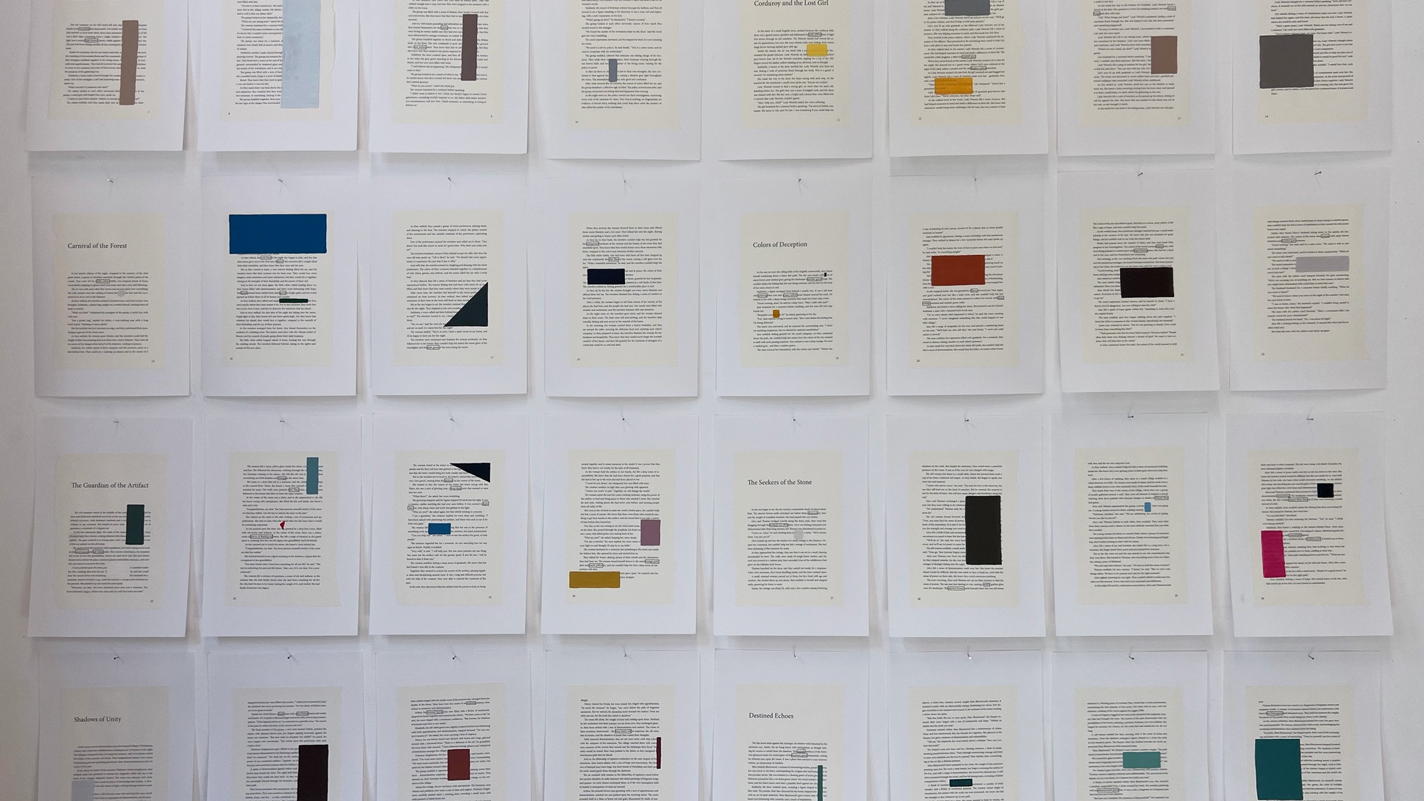 Een vooraanzicht van een witte muur waarop tientallen witte vellen papier in een strak raster zijn opgehangen. Elk vel bevat een gedrukte tekst waarbij bepaalde woorden zijn omcirkeld en gecombineerd met één of meer geometrische kleurvlakken (vierkanten, rechthoeken, driehoeken).