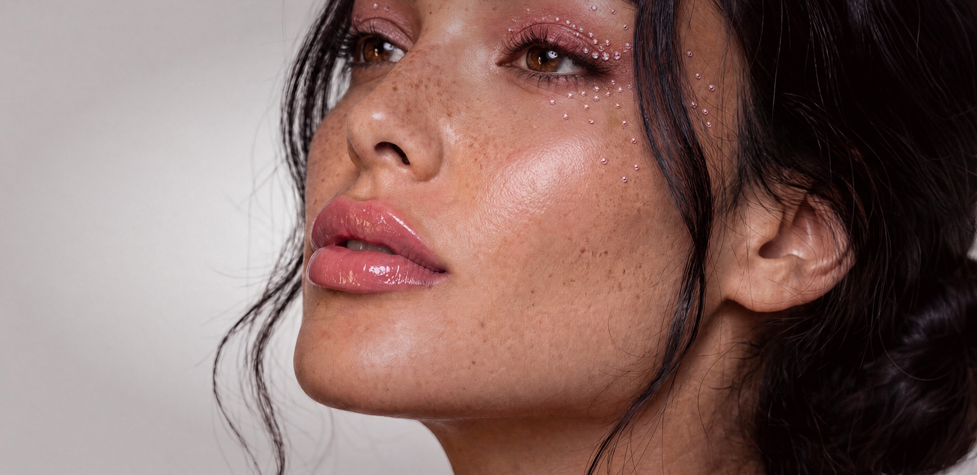 Sol d'Amore Pink October website banner: a real model photo with AI-retouched pink eyeshadow, glossy lips and small pink rhinestones on the eyelid and cheek