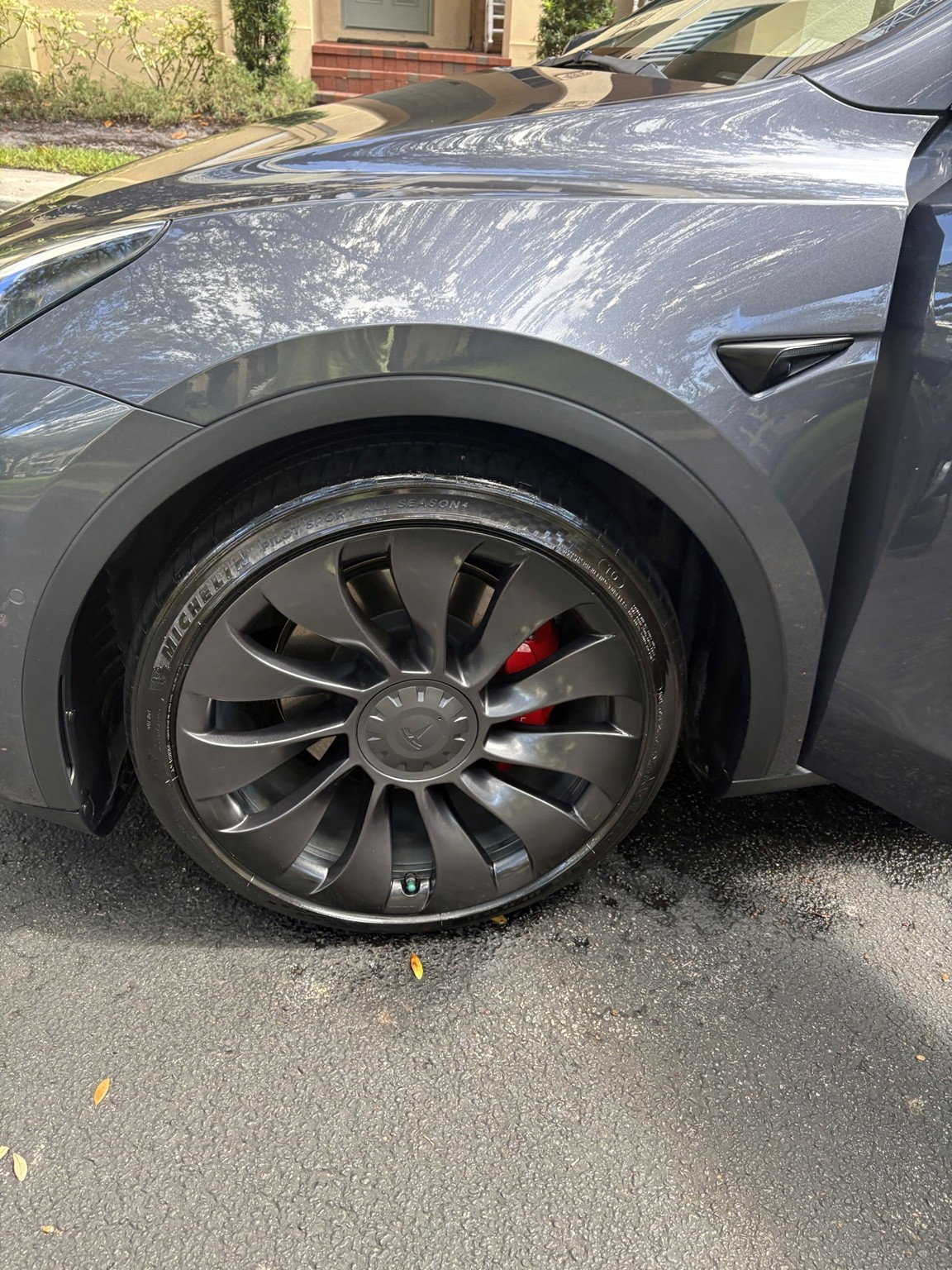 Close-up of a gray Tesla Model Y front wheel during mobile detailing