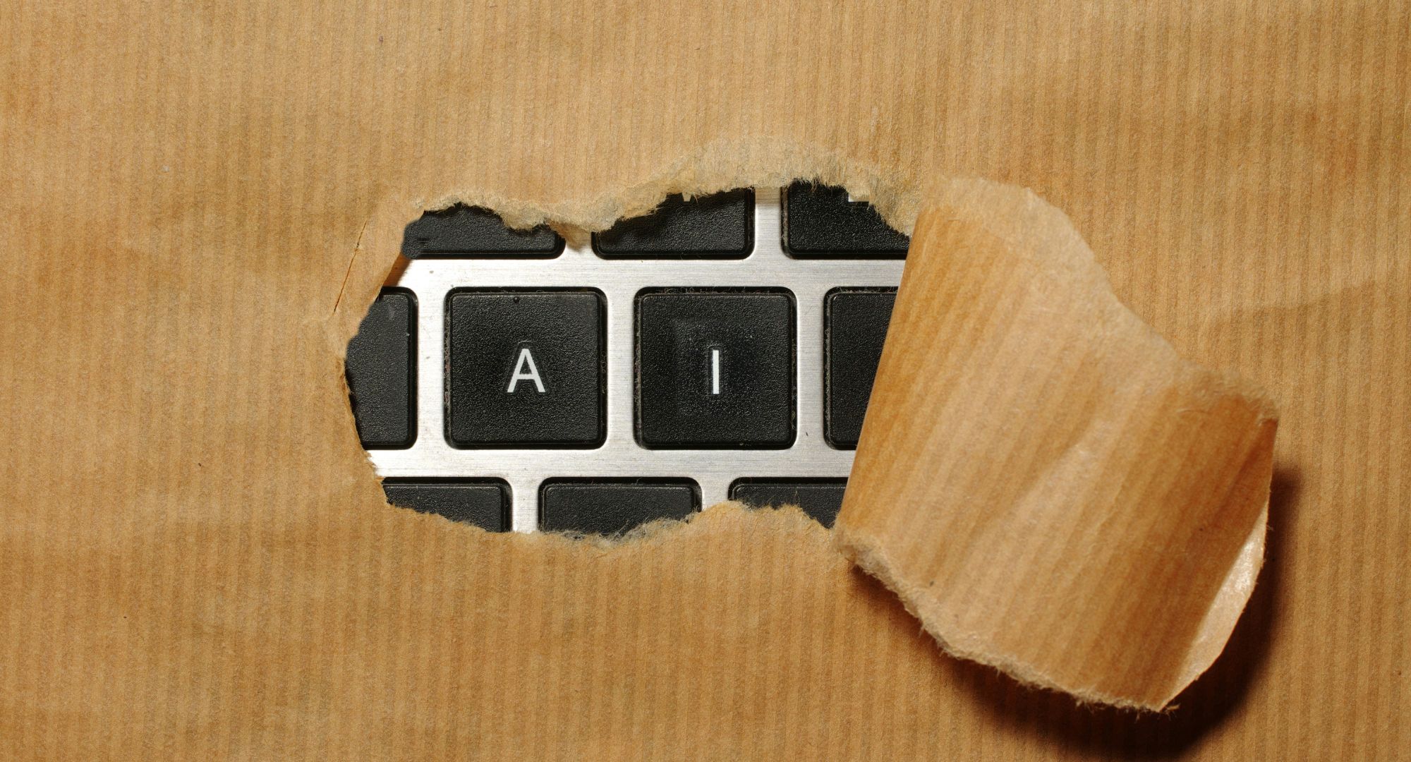 um pedaço de papelão com o centro rasgado aparecendo as teclas "A" e "I" através dele