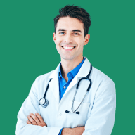 Smiling male doctor with dark hair, wearing a white coat and a blue shirt, with a stethoscope around his neck, standing against a black background.