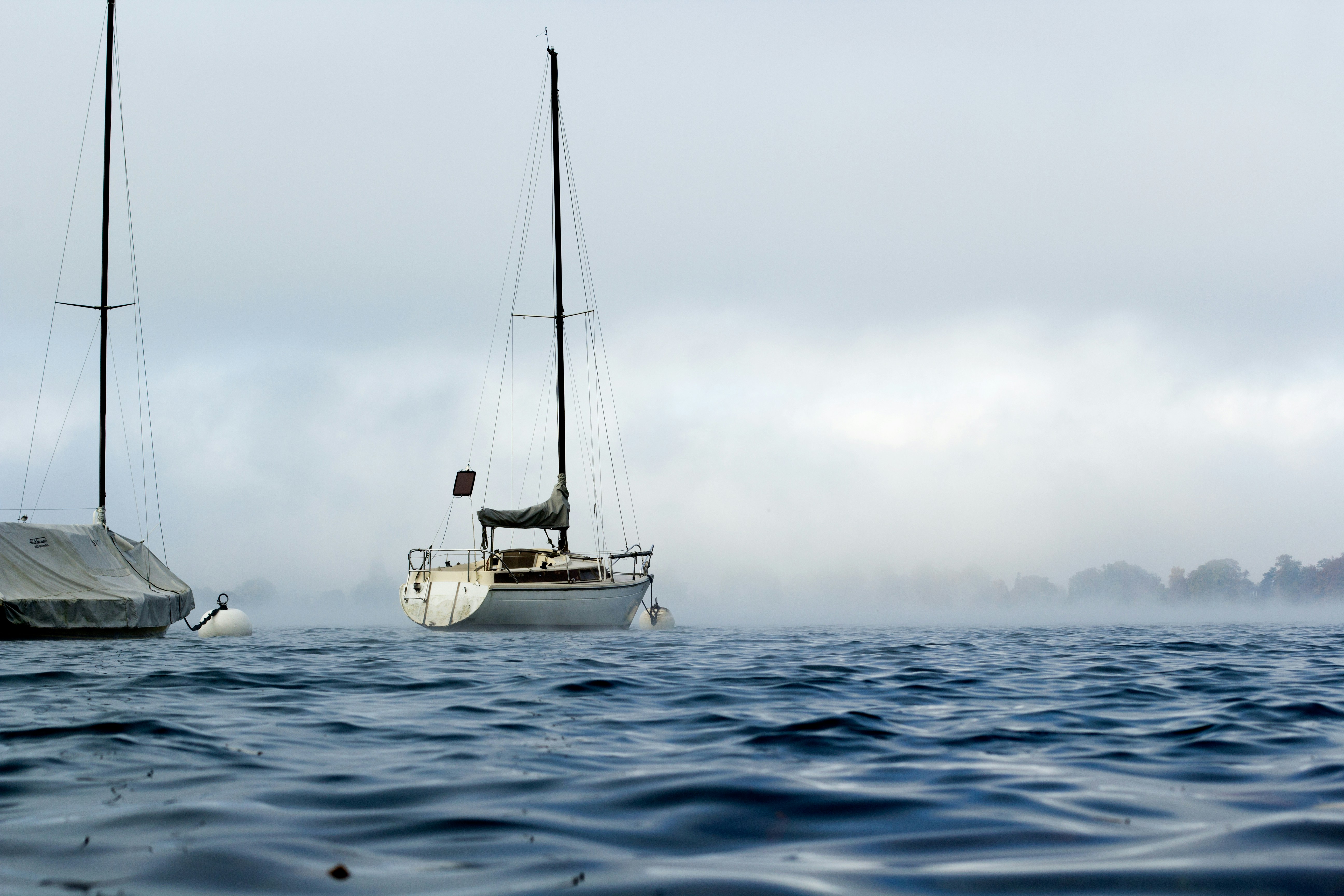 two boats on ocean under cloudy sky