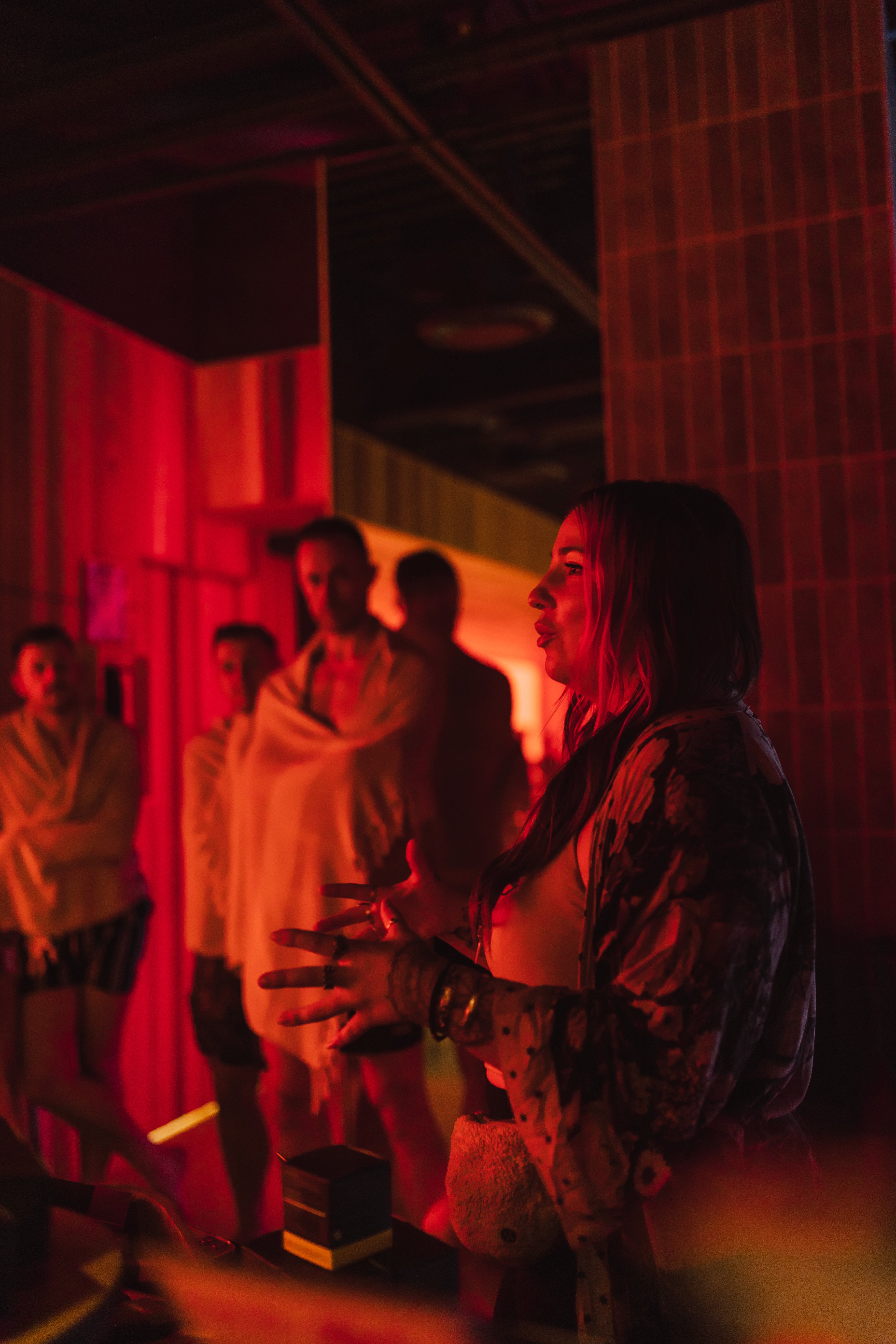 Woman siting in lotus pose meditating over a brightly lit green hill