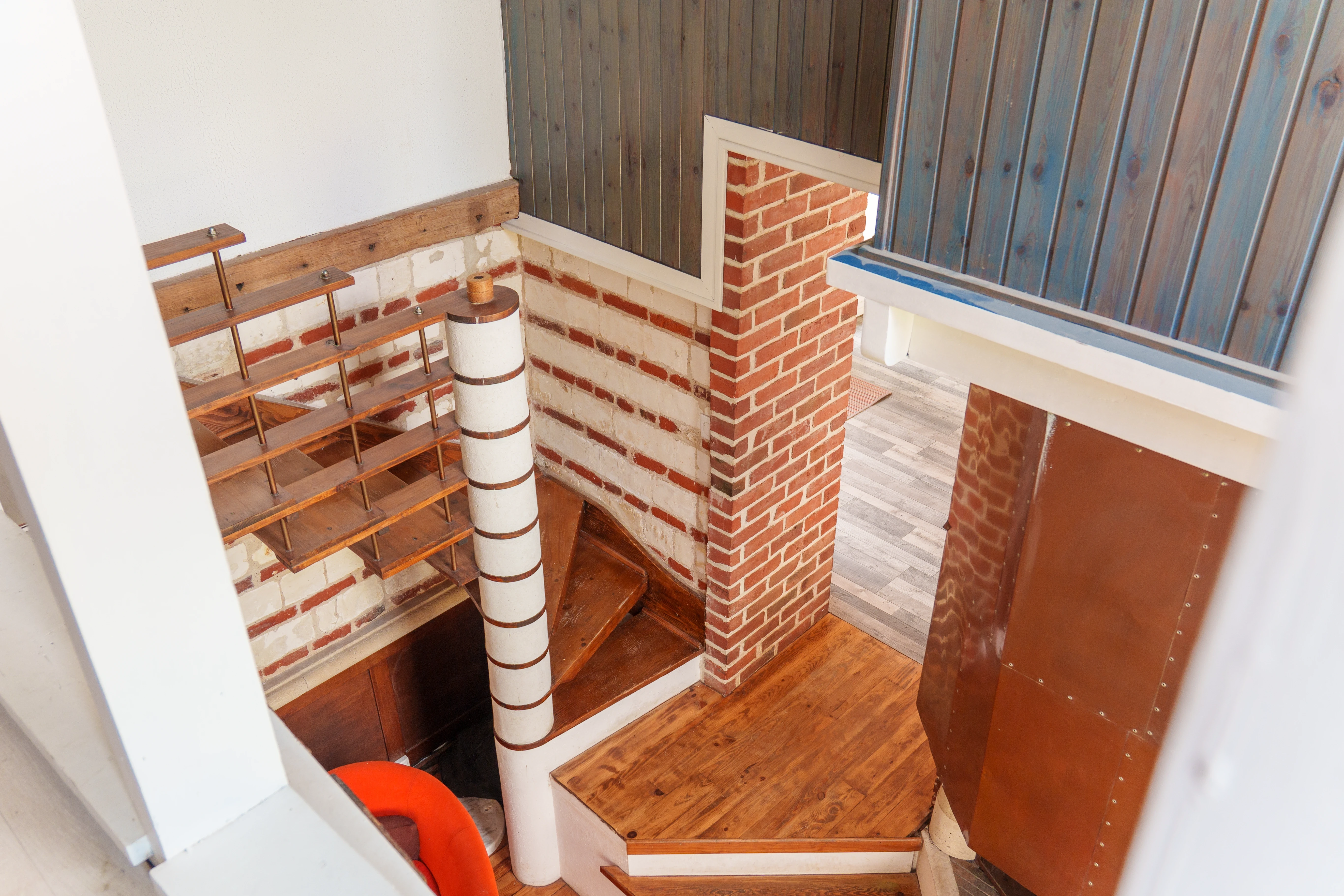 Terracotta wall interior with wooden architectural elements and dramatic natural light.