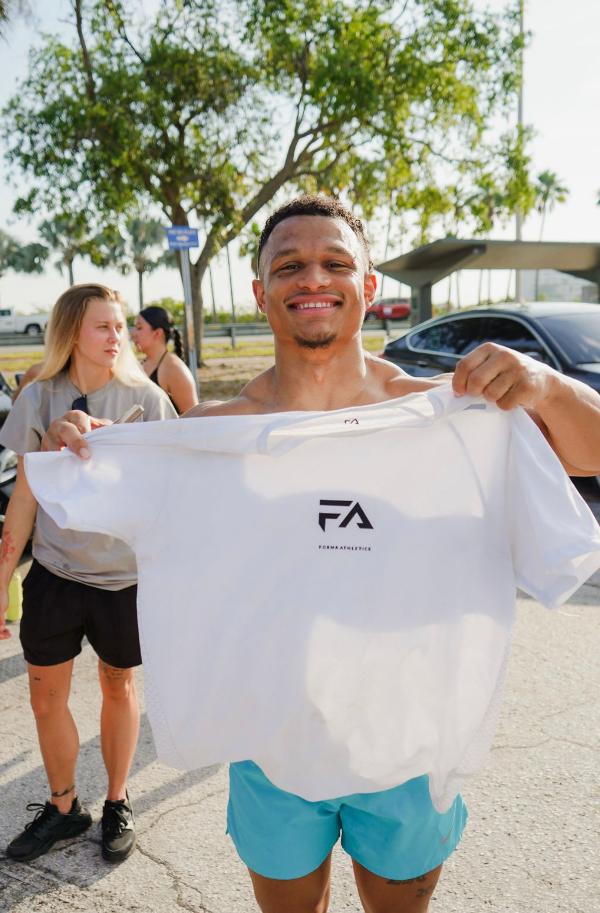 An image of someone holding up a Forma Athletic t shirt