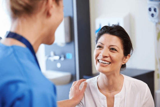 a woman in a gray shirt is smiling