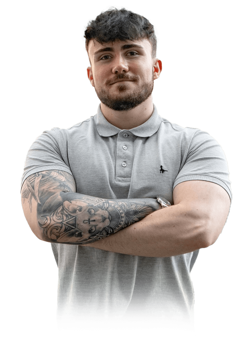 Jamie from Reizia Digital with short dark hair, a grey polo shirt and tattoos. He has his arms crossed.