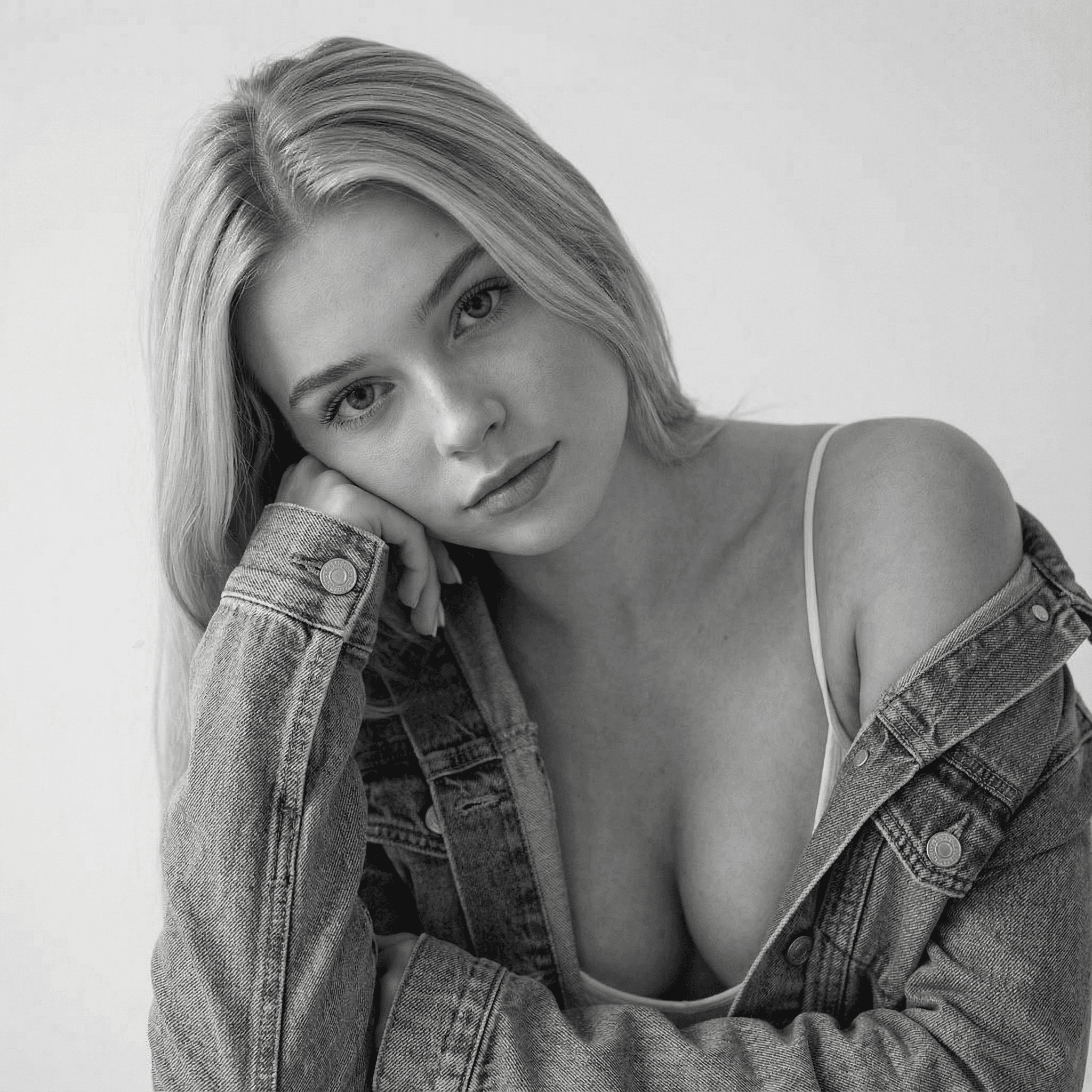 KI-Model im grauen Oversize-Blazer mit blauer Bluse und Brille steht lässig in einer Tür, wirkt modern, ruhig und stilvoll in urbanem Ambiente.