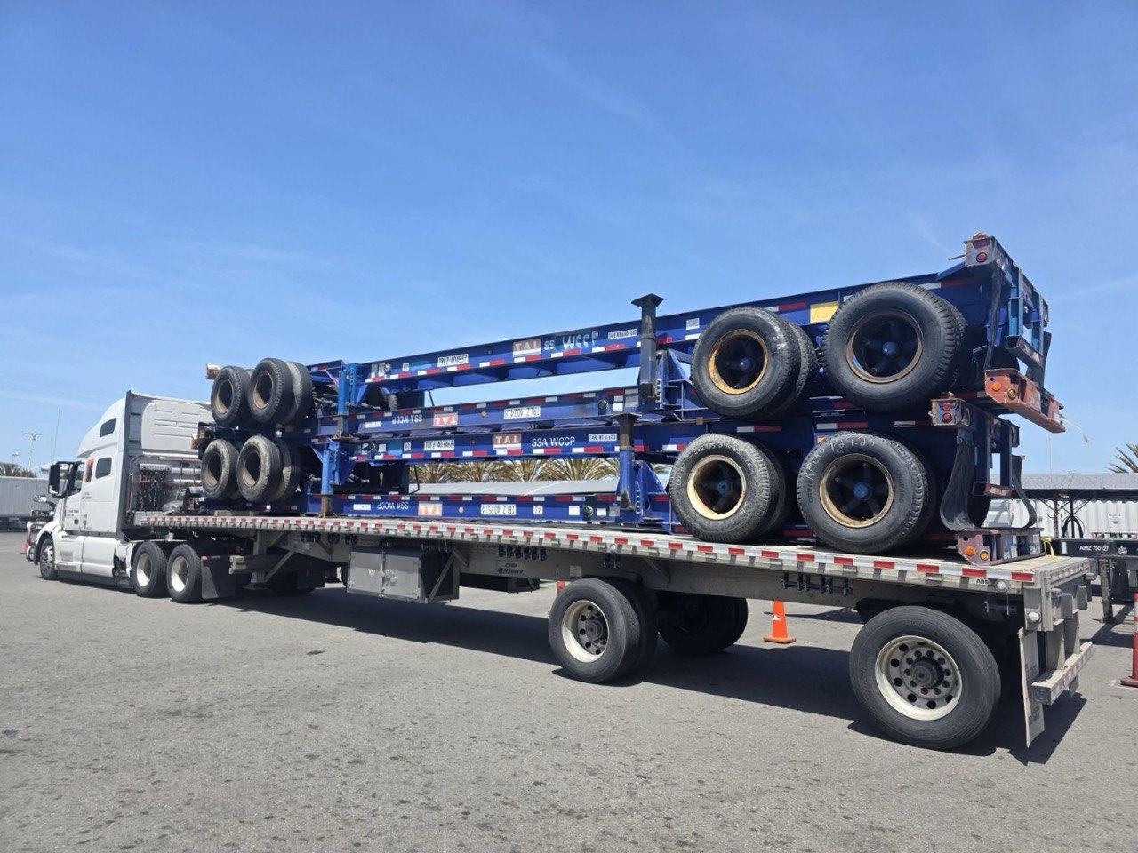 Stacked trailer and chassis equipment on a flatbed.