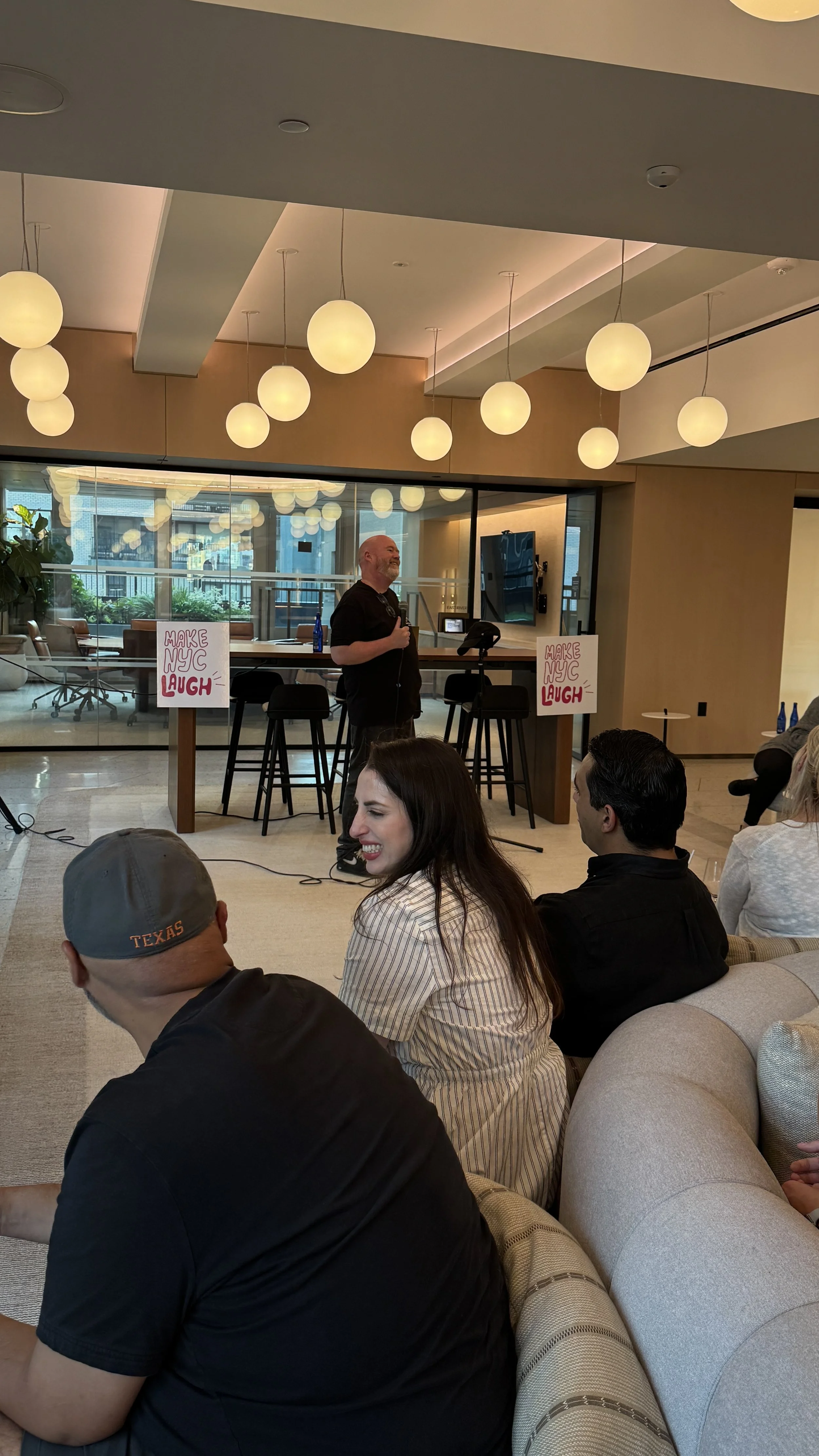 Solo stand-up comedian with a microphone performing in front of an intimate audience