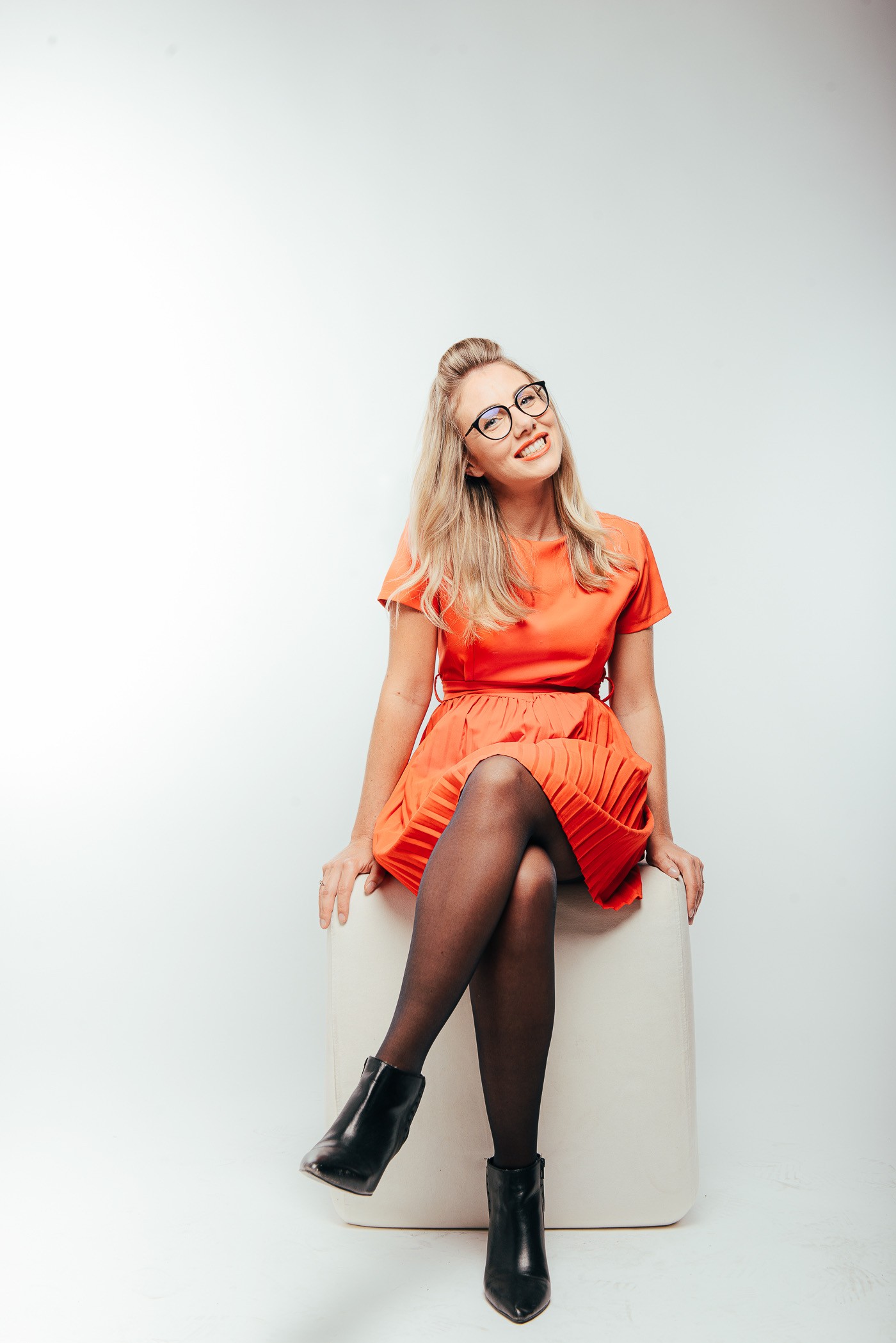 héléne sido robe rouge collant noir et bottes noires, lunettes noires et rouges à levres rouge