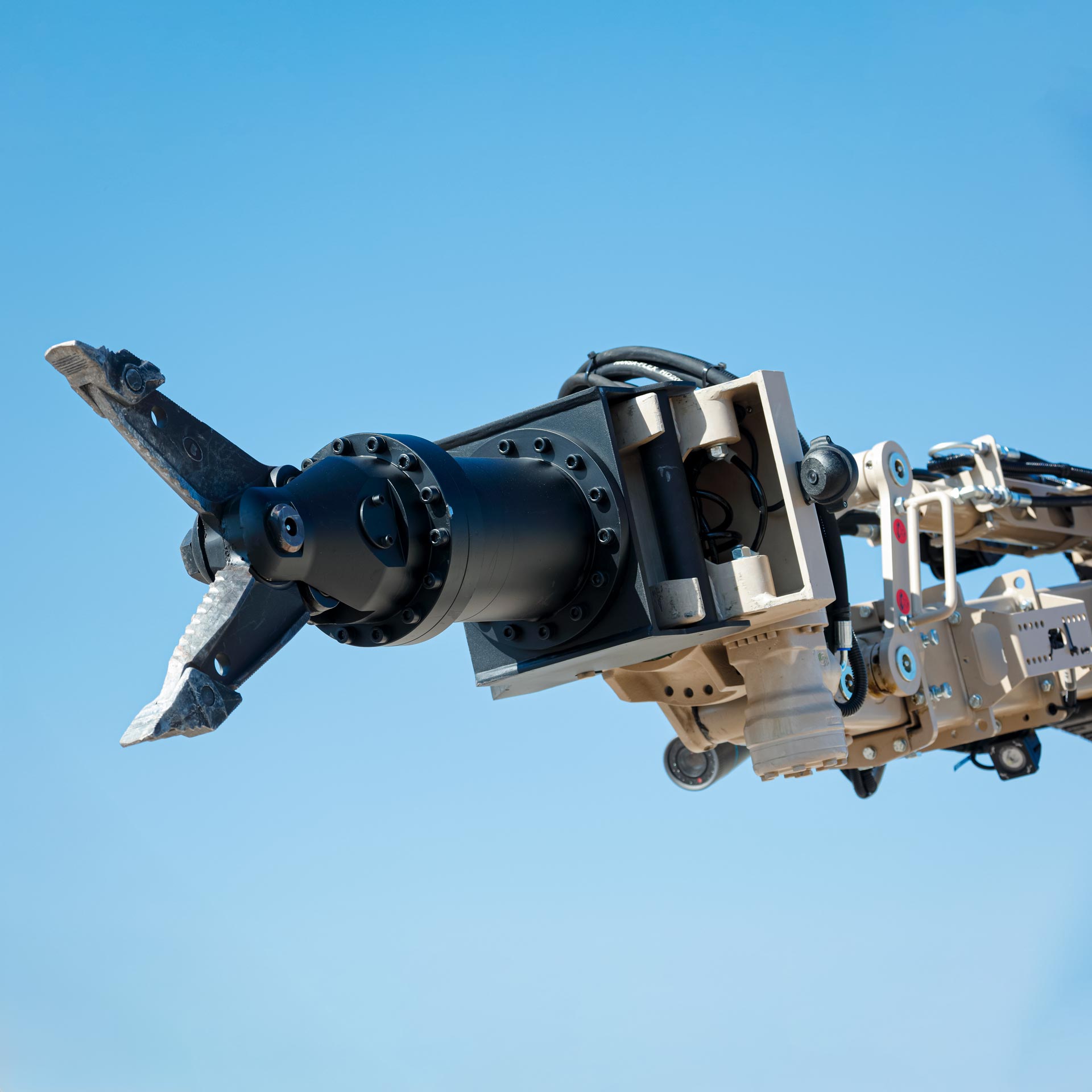 Close-up of GCS shears spreader tool mounted on a manipulator arm for airfield clearance and EOD operations.