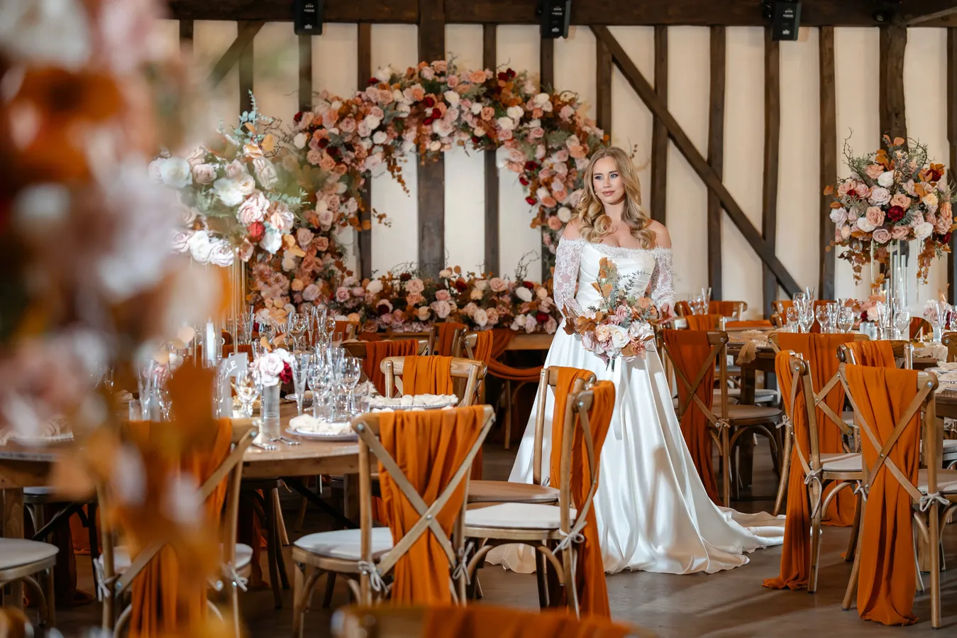 Bride holding a bouquet in a decorated wedding venue.