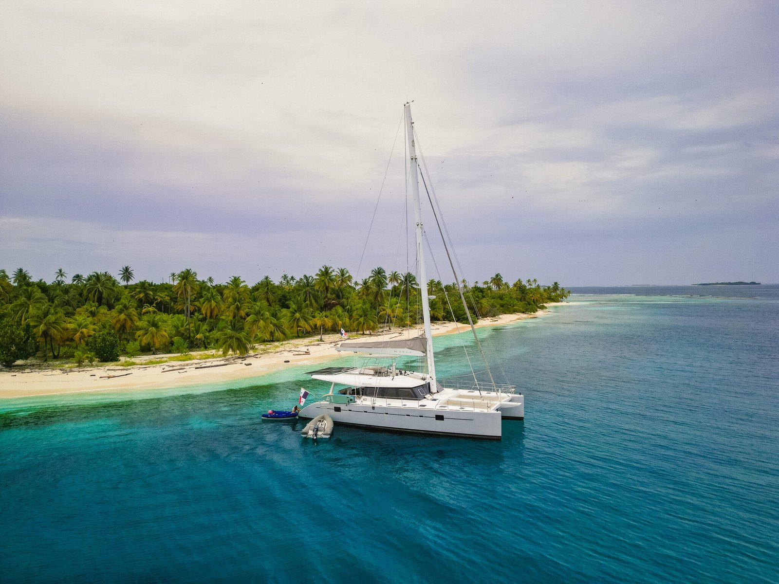 A beautiful "arrival" shot. The Nomade seen from the air waiting in the turquoise water. The "prize" at the end of the journey