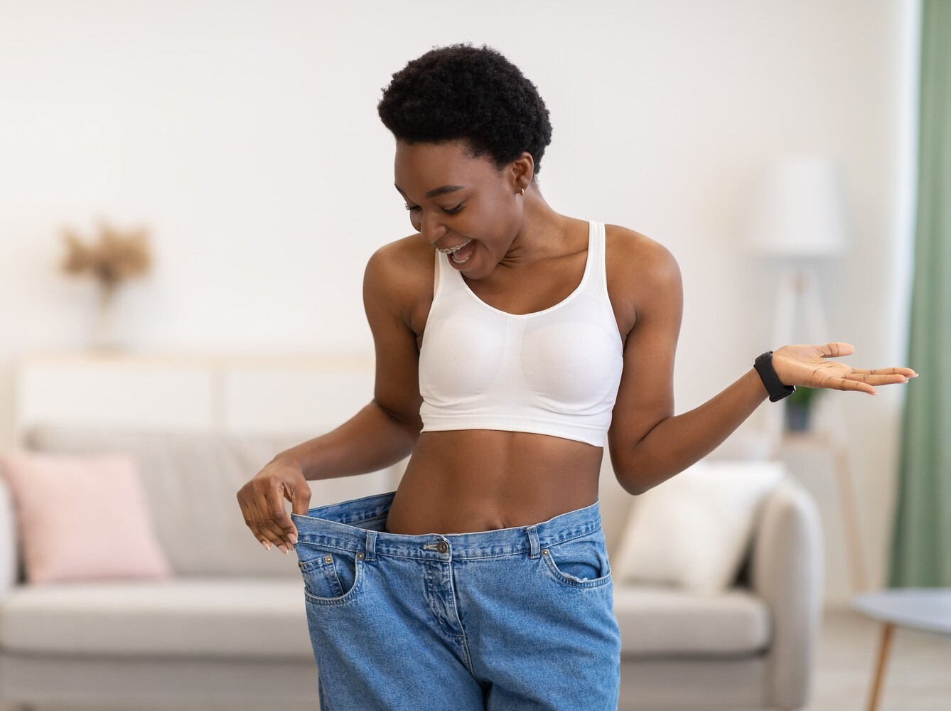 woman checking her results from sauna weight loss alongside a training routine using an old pair of jeans